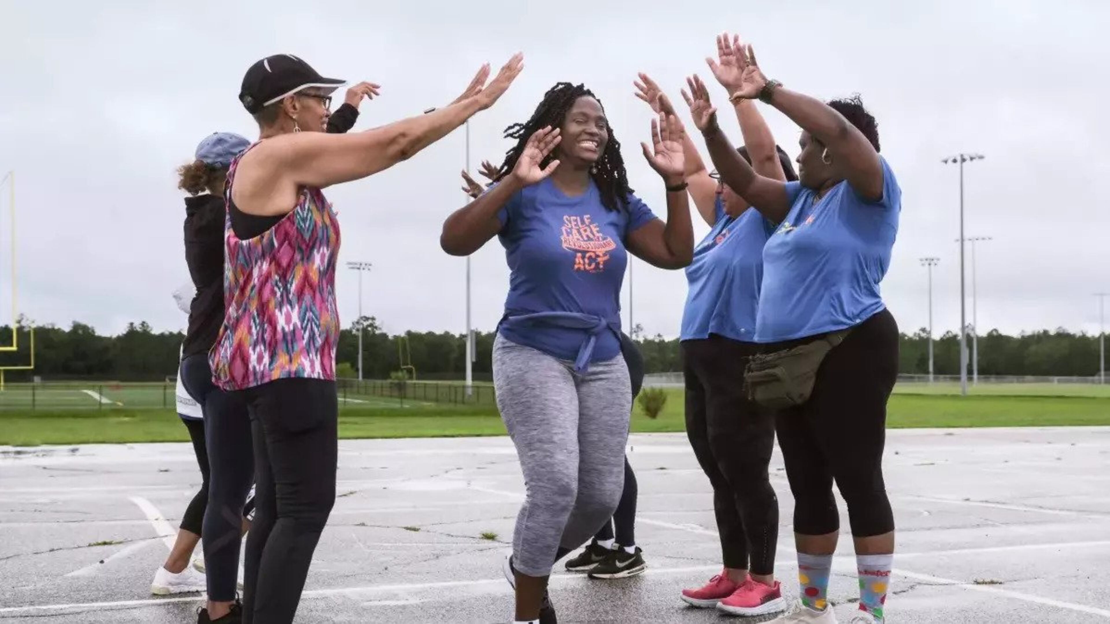 Ericka Davis runs through the "victory bridge" to celebrate self care at the end of a GirlTrek walk at Hendrix Park on Saturday, July 29. (Photo Courtesy of Justin Taylor/The Current)
