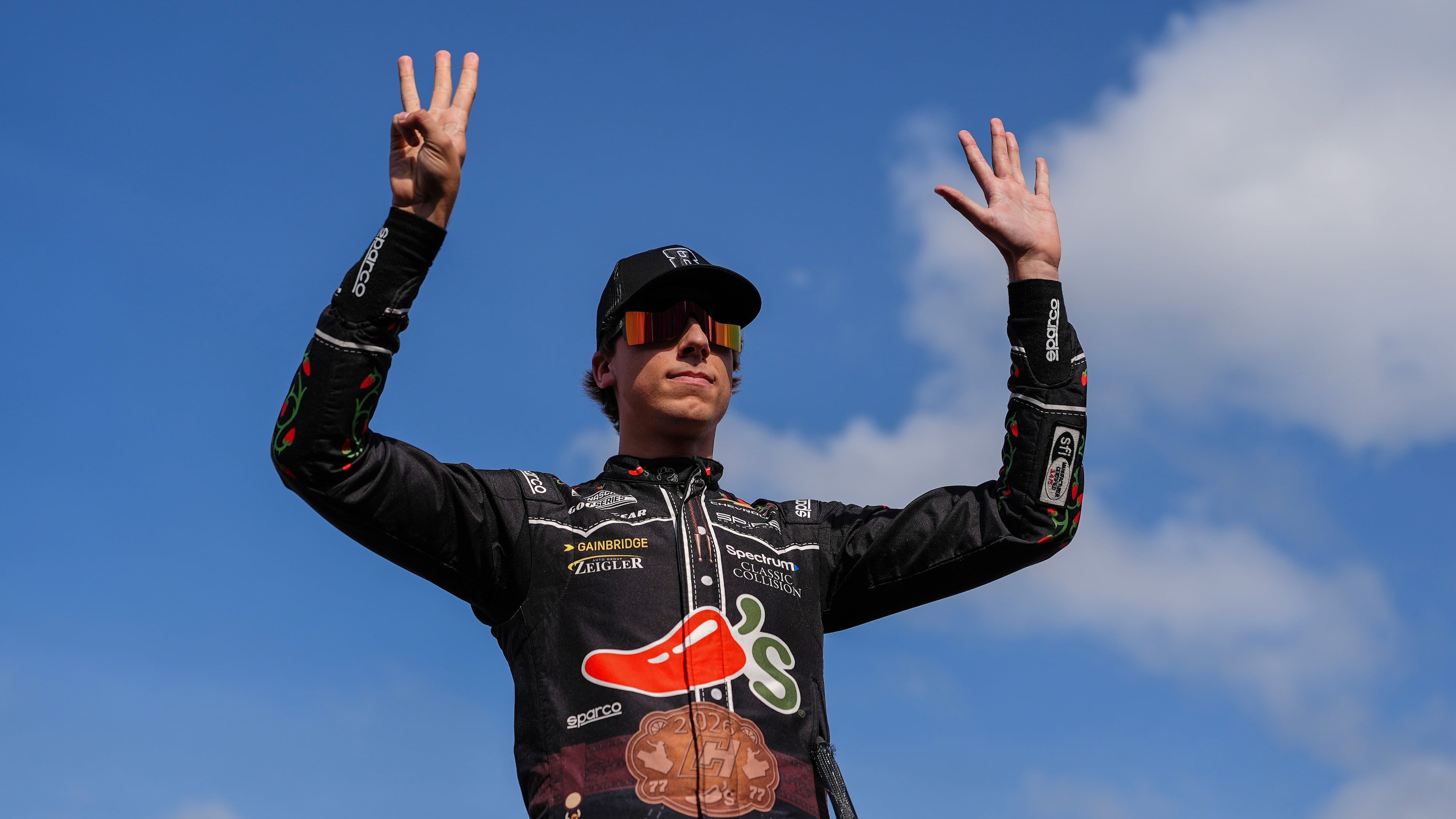 Carson Hocevar holds up eight fingers in honor of late driver Kyle Busch prior to a NASCAR Cup Series auto race, Sunday, May 24, 2026, in Charlotte, N.C. (AP Photo/Matt Kelley)