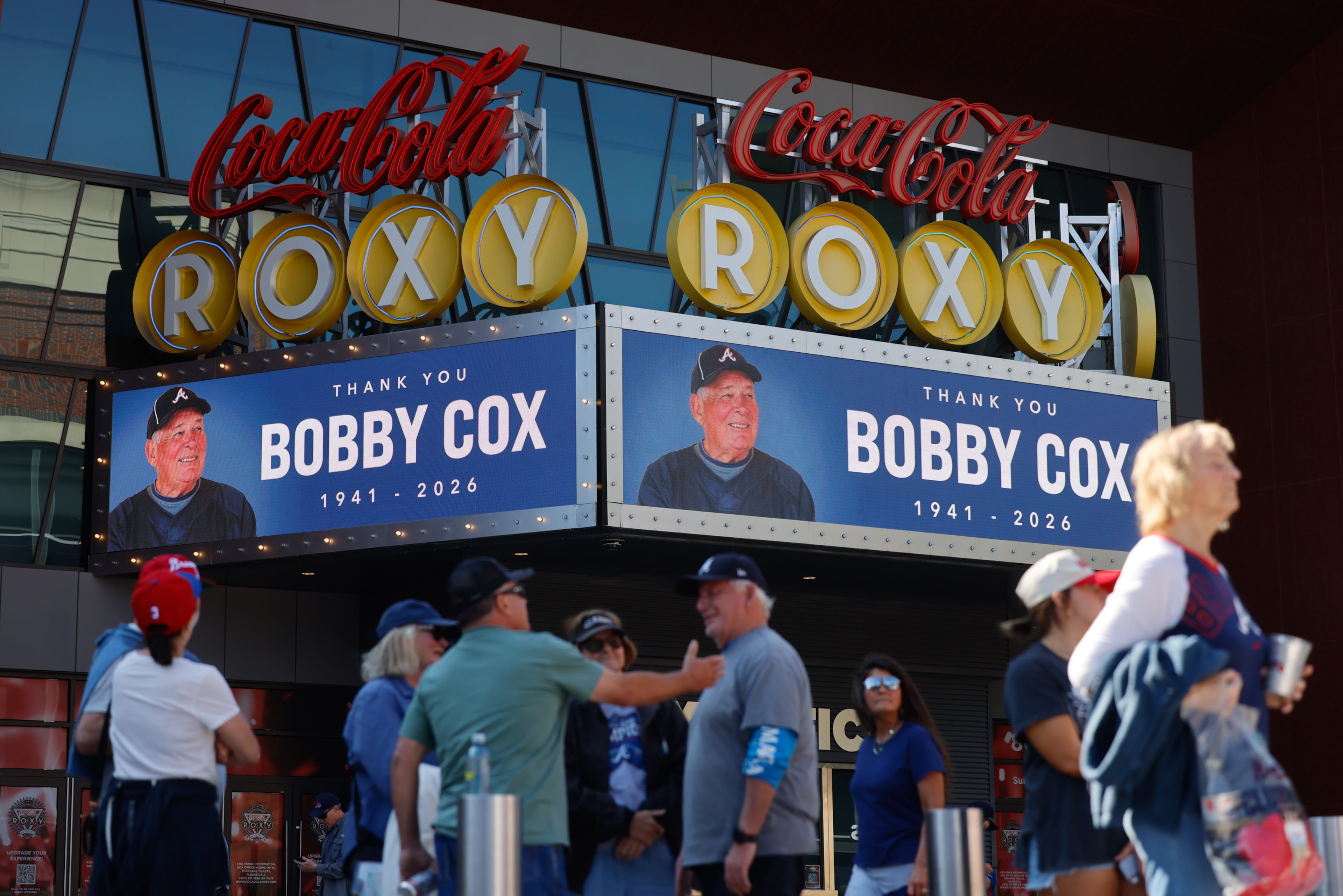 Fans walk in front of a tribute to late legendary Braves manager Bobby Cox on the Roxy marquee in Truist Park in Atlanta on Tuesday, May 12, 2026. (Arvin Temkar/AJC)