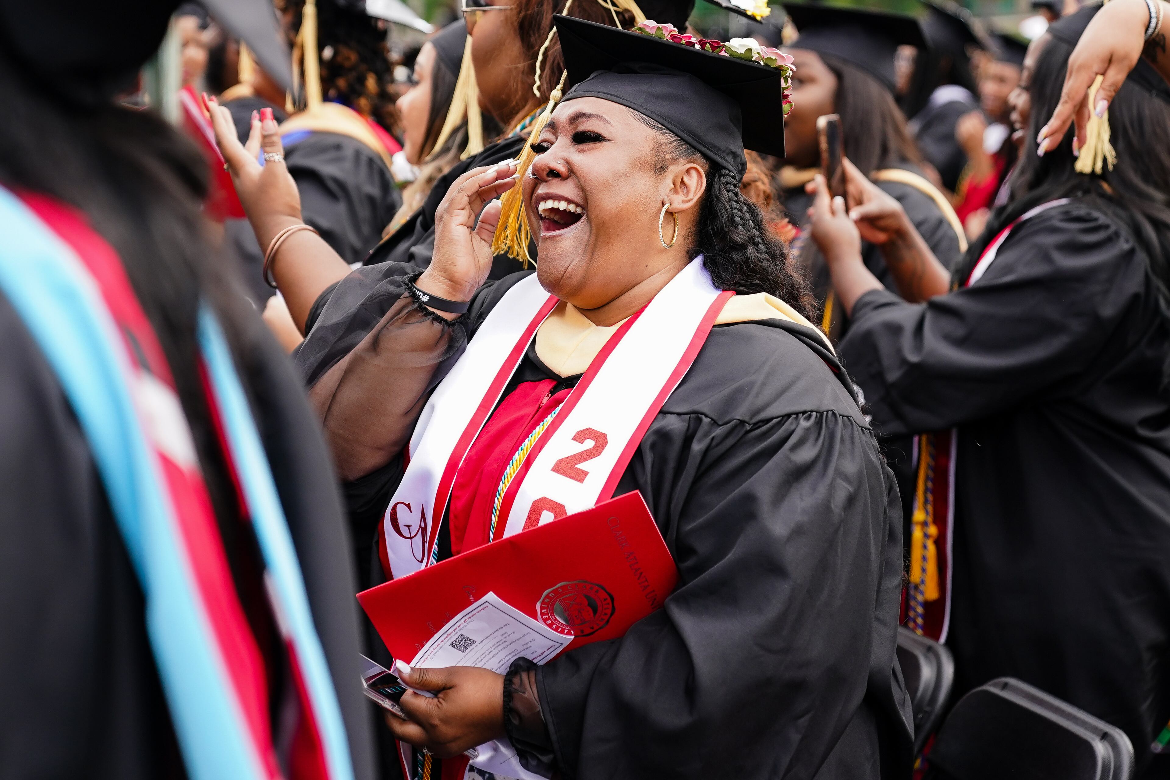 Students react to the announcement by Pinky Cole in her commencement address that she would gift and set up LLCs for every graduate at Clark Atlanta University’s 33rd Commencement Exercises, at Panther Stadium on Saturday, May 14, 2022, in Atlanta. (Elijah Nouvelage for The Atlanta Journal-Constitution)
