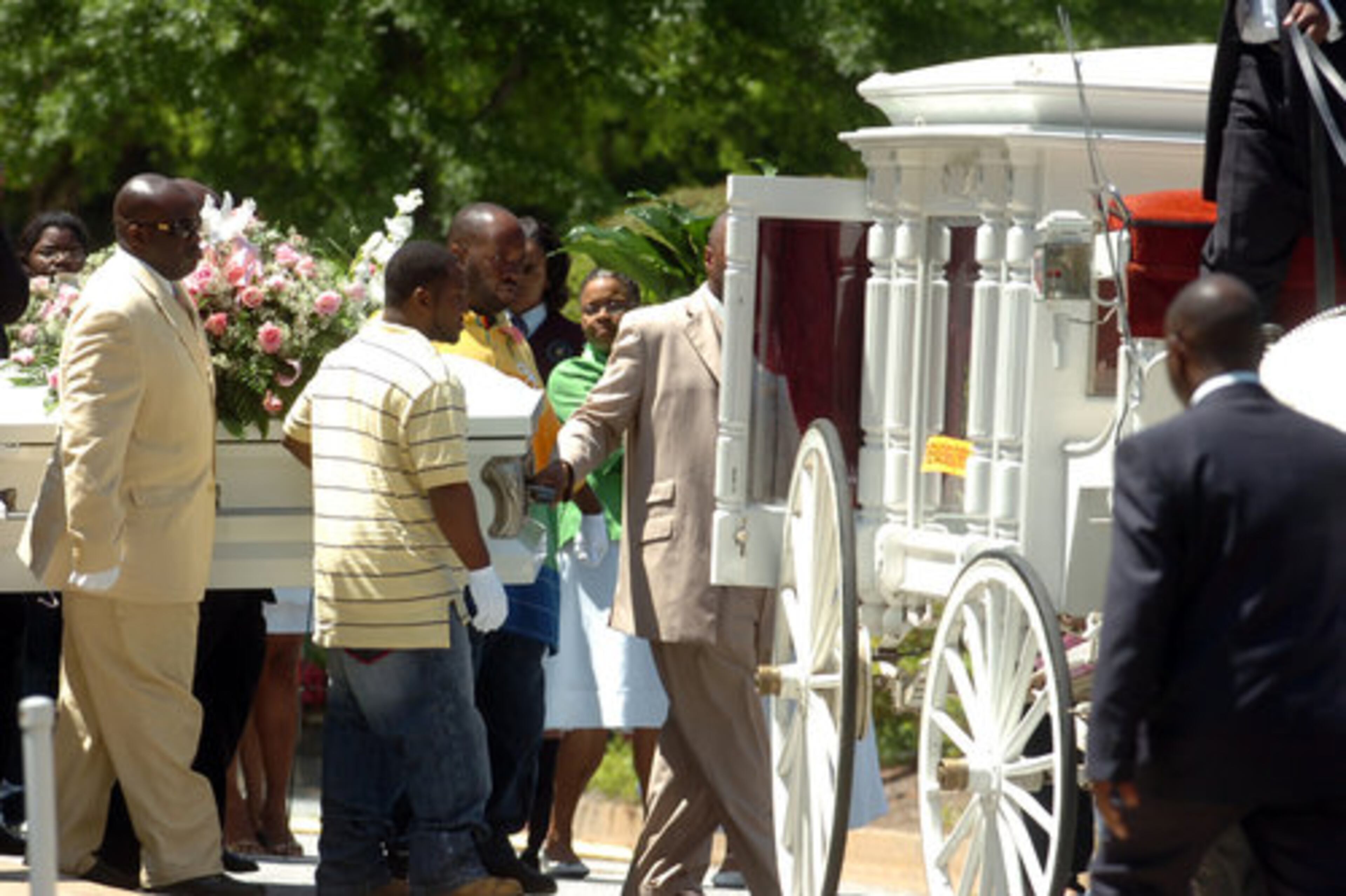 Pallbearers carry Morgan Johnson's casket to a horse-drawn carriage following funeral services Monday.