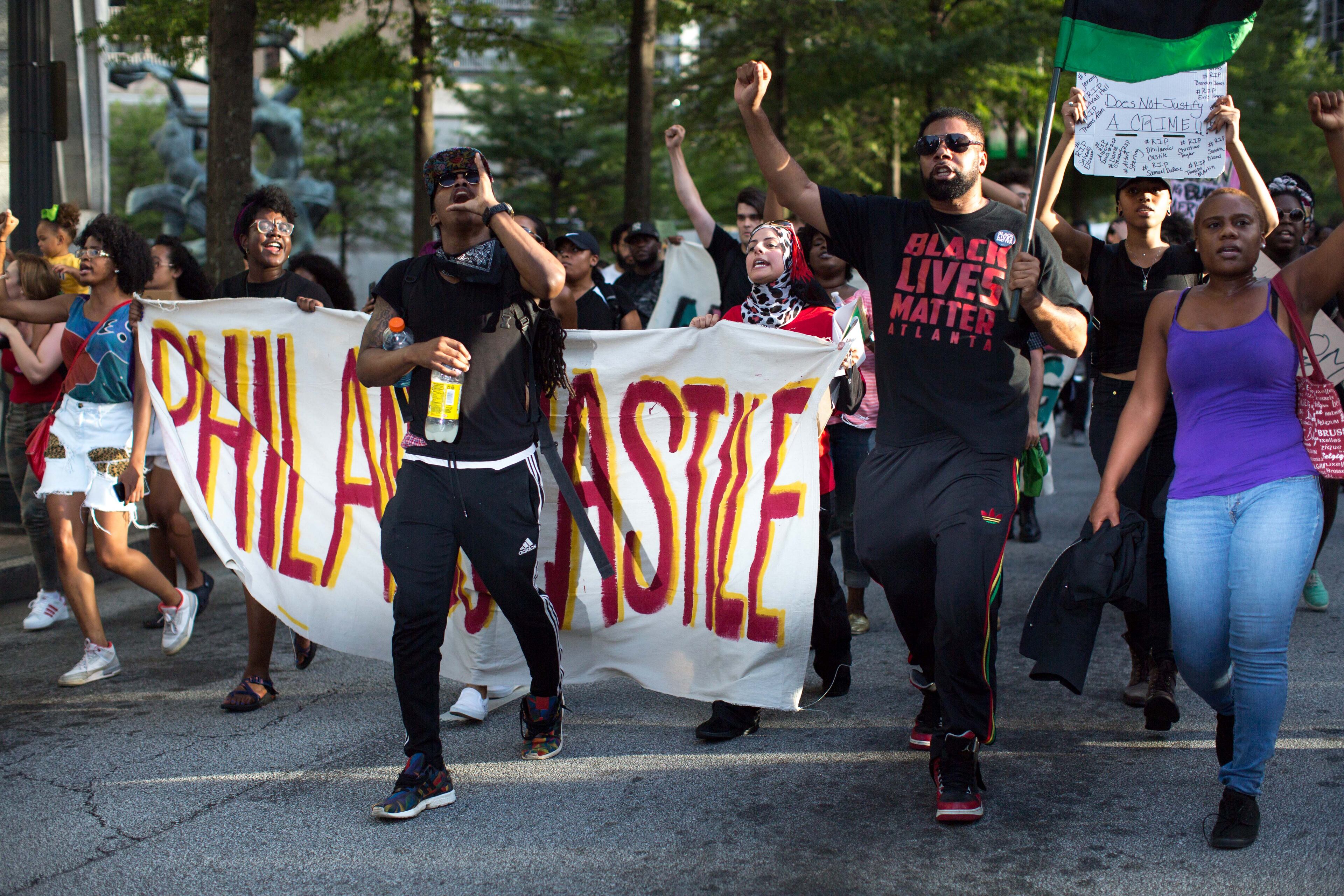 Demonstrators carry signs as they march down Peachtree Street to Piedmont Park, Thursday, July 7, 2016, in Atlanta. Demonstrators gathered in response to the death of 37-year-old Alton Sterling, who was killed by Baton Rouge police outside of a convenience store where he was selling CDs and Philando Castile, who was shot and killed when Minnesota police stopped him for a traffic violation on Wednesday evening. BRANDEN CAMP/SPECIAL