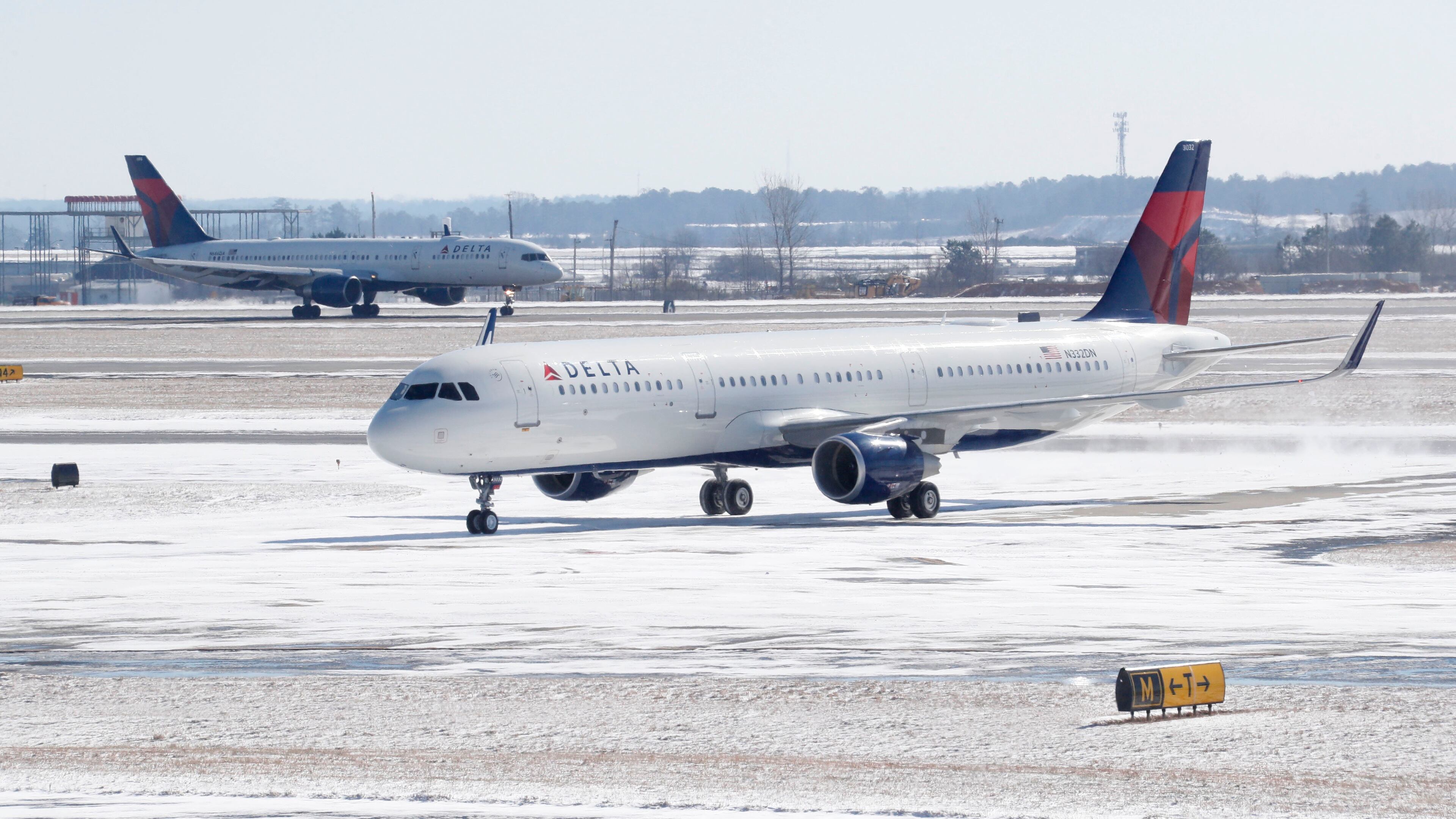 A Delta jet pushes through last week’s snowfall at Hartsfield-Jackson International Airport. BOB ANDRES /BANDRES@AJC.COM