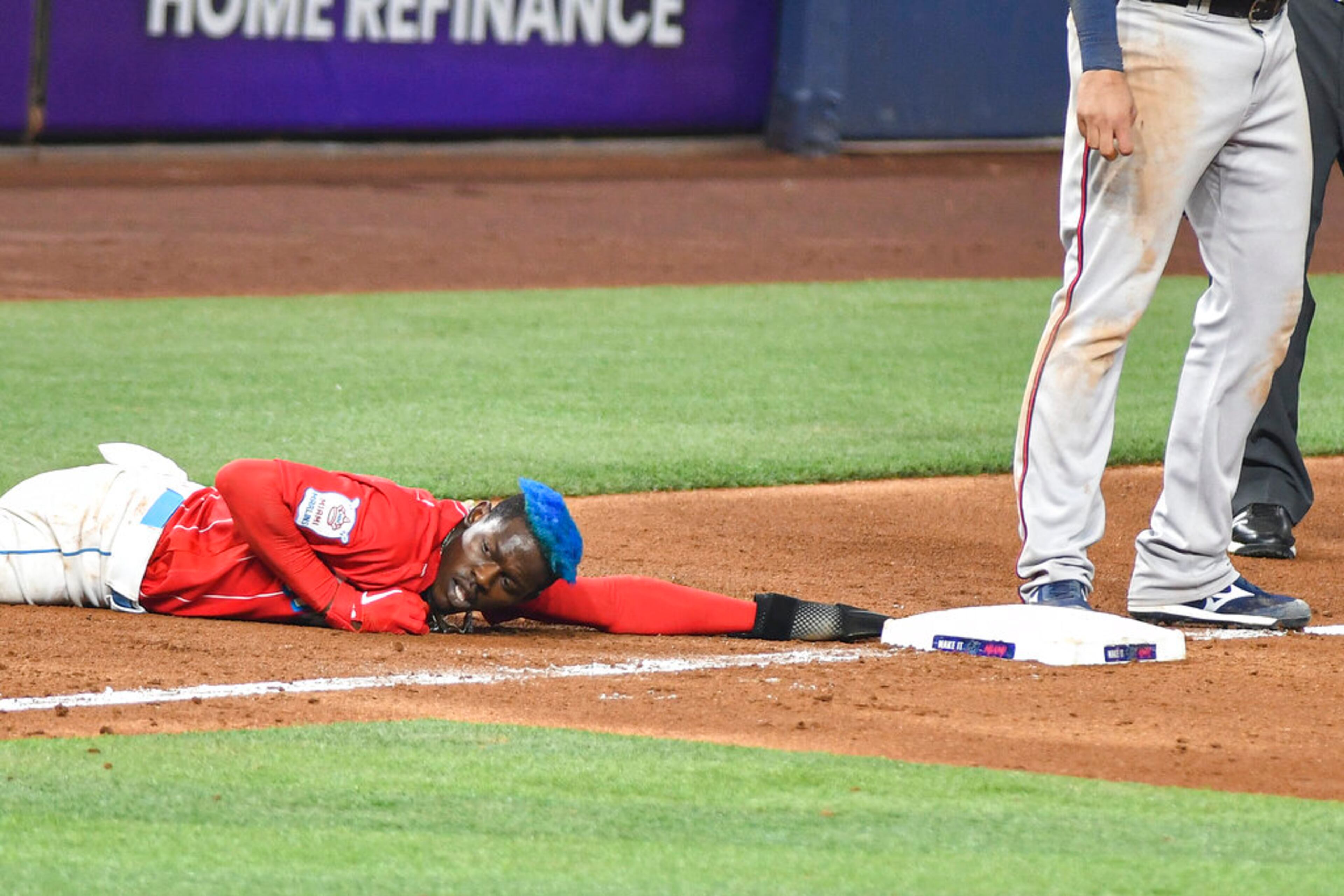 Miami Marlins' Jazz Chisholm Jr. slides into third base, advancing on a double by Garrett Cooper during the ninth inning of baseball game against the Atlanta Braves, Saturday May 21, 2022, in Miami. (AP Photo/Gaston De Cardenas)
