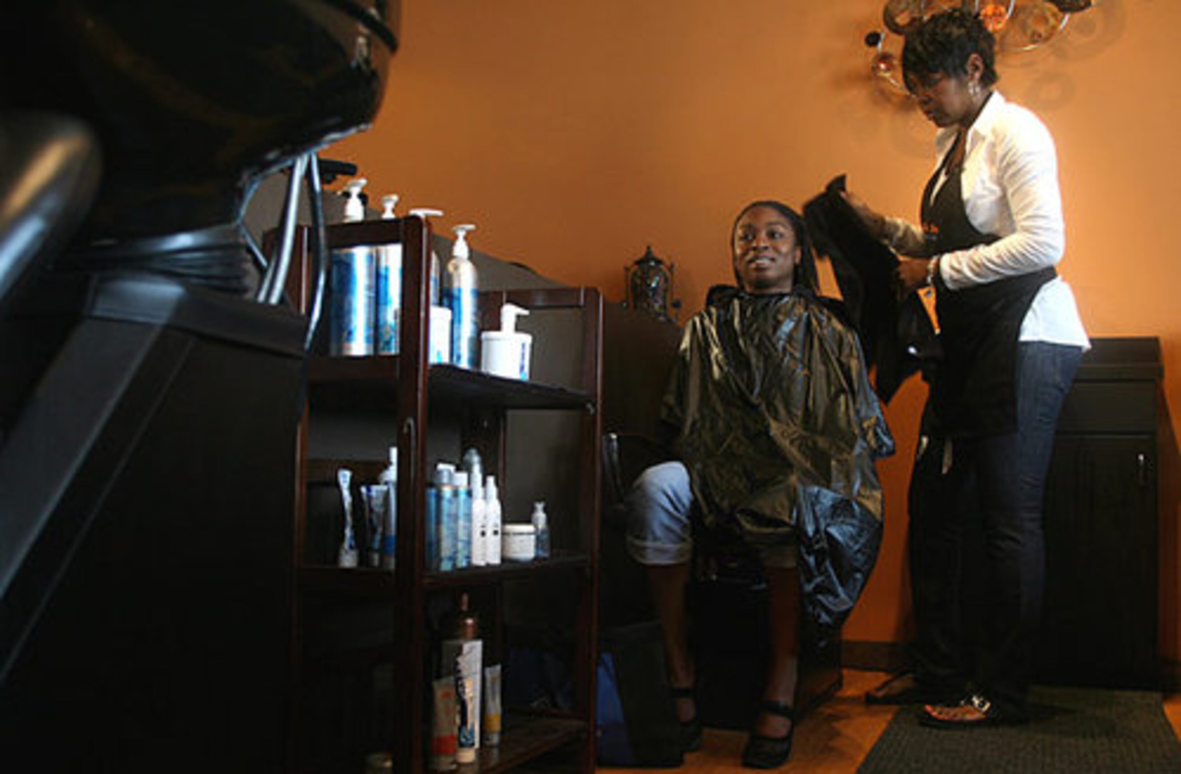 Master stylist and co-owner Najah Aziz (right) dries off Tushynya Gardiner, 22, after a shampooing. Gardiner, who plans to become a nursing assistant, says the haircut will "spruce up her confidence" and help her accomplish her goals. Although she has fallen on hard times, Gardiner said she believes her makeover is "part of the miracle I am going to get for myself."