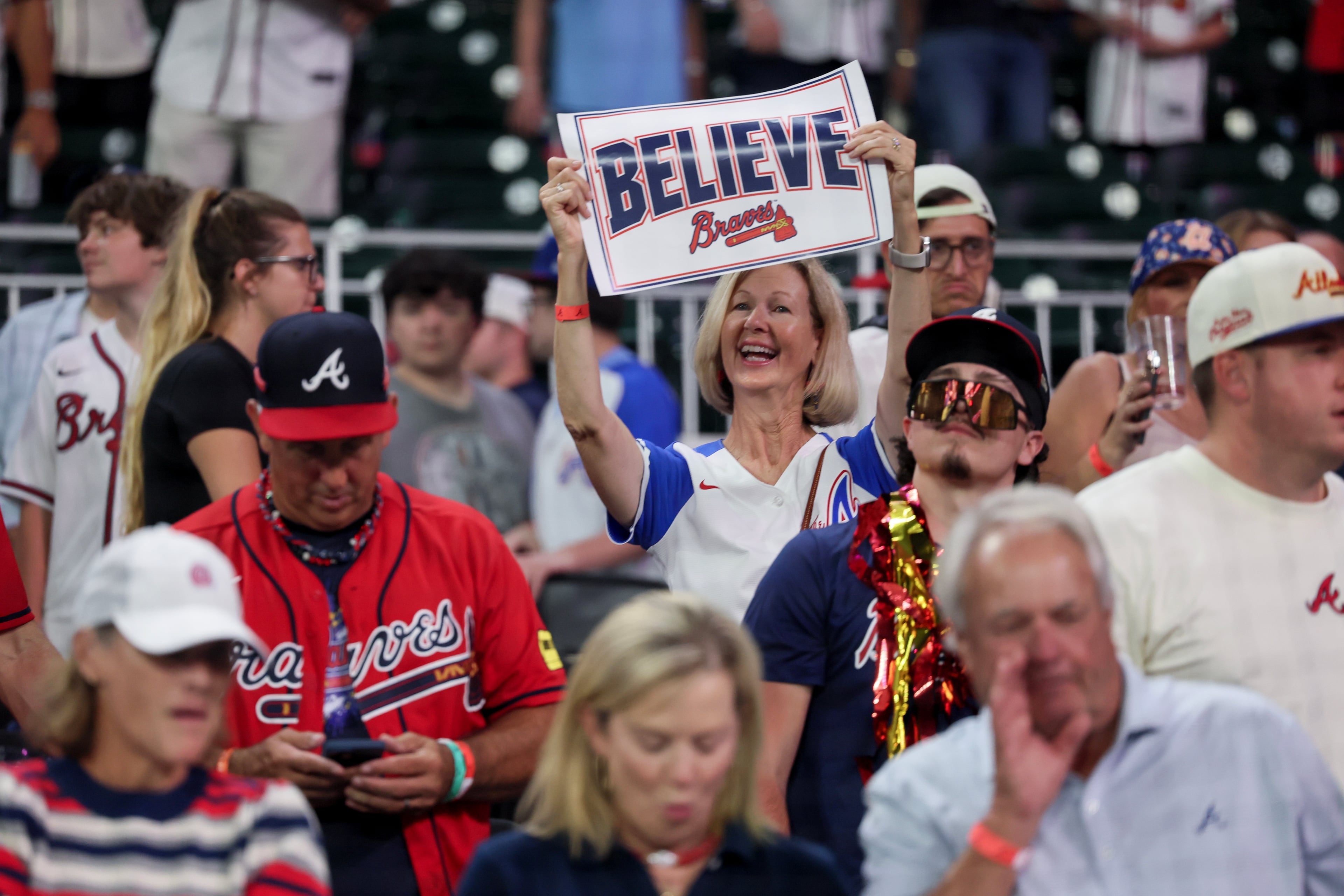 Fans watch the Braves celebrate on the field after defeating the Phillies to win their NL Wild Card Series on Thursday, Oct. 1, 2026, at Truist Park in Atlanta. (Jason Getz/AJC)