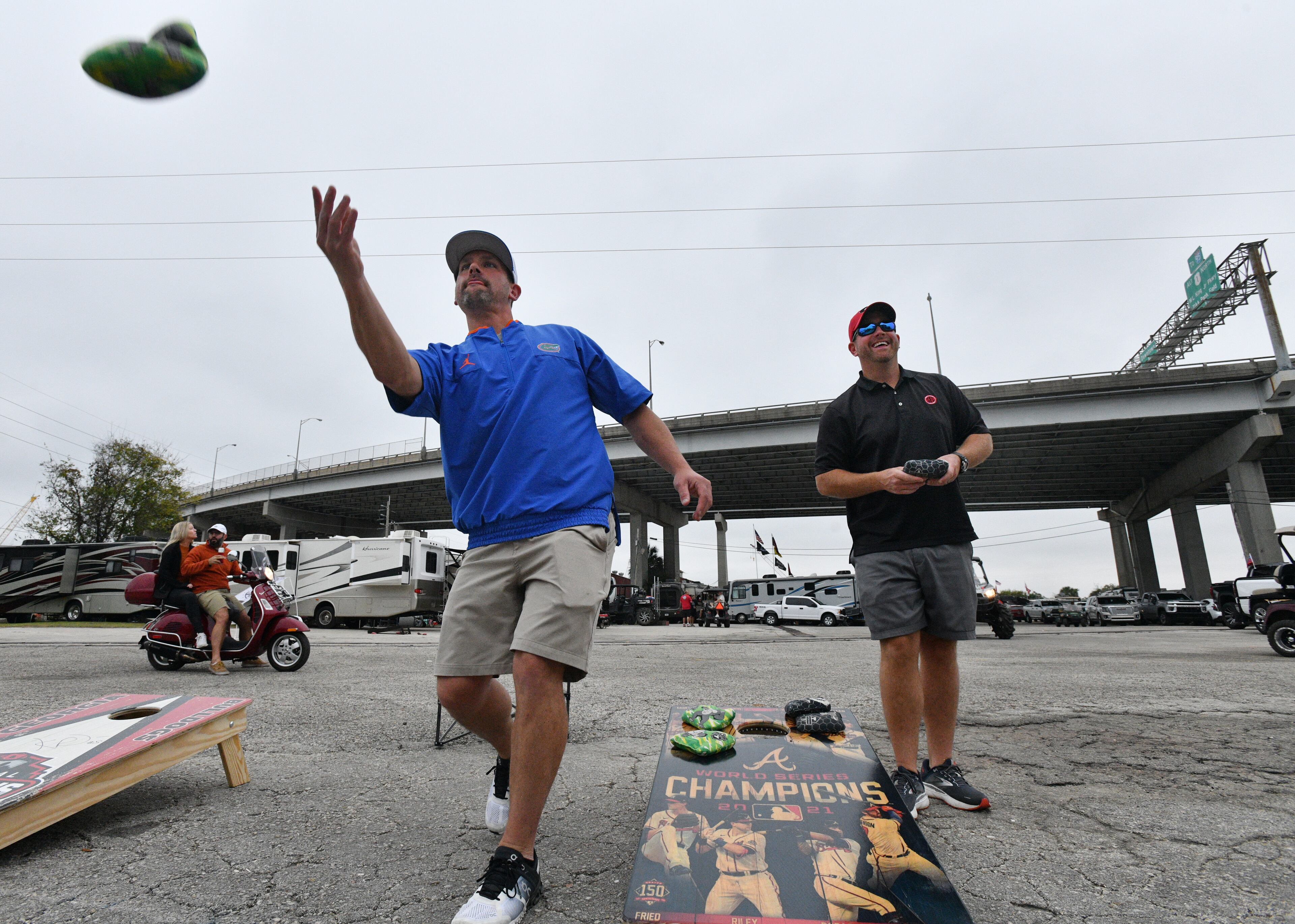 Florida fan Jared Johnson (left) and Georgia fan Mieko Burcich play a bean-bag toss game. (Hyosub Shin / Hyosub.Shin@ajc.com)