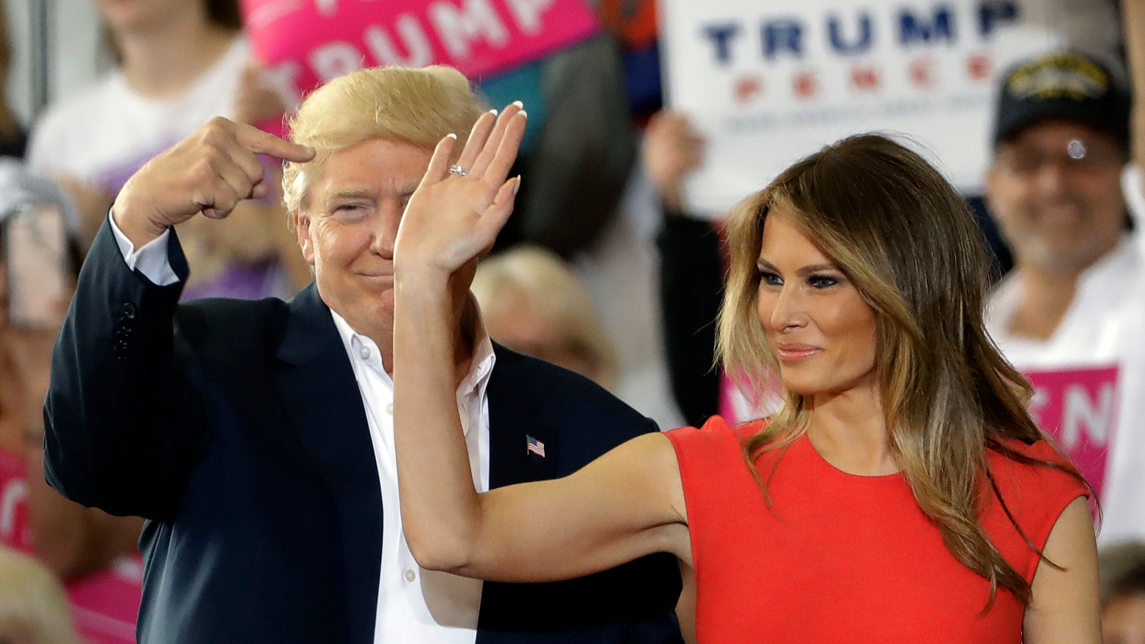 President Donald Trump points to his wife, first lady Melania Trump during a campaign rally Saturday, Feb. 18, 2017, at Orlando-Melbourne International Airport, in Melbourne, Fla. (AP Photo/Chris O'Meara)