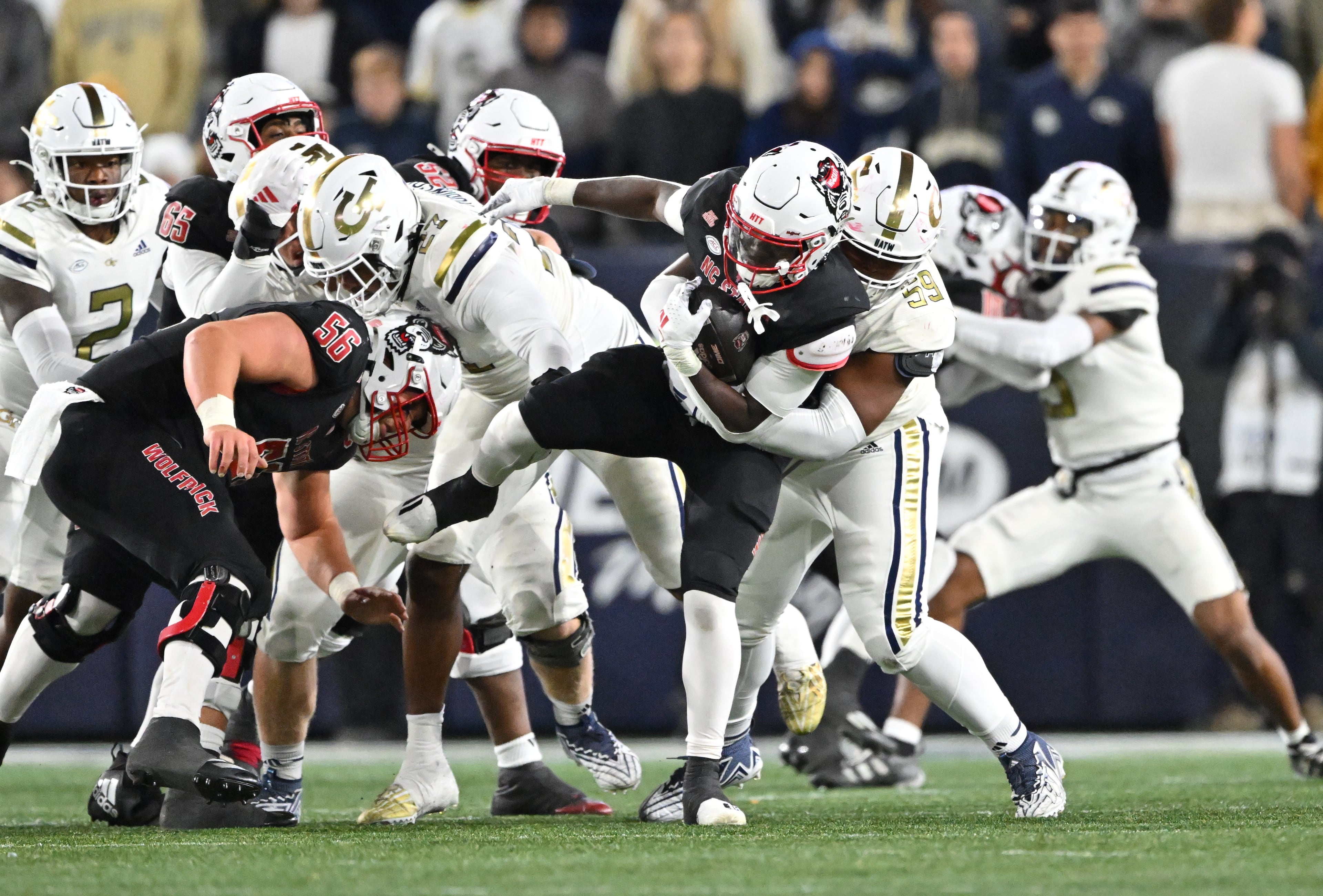 Georgia Tech defensive lineman Thomas Gore (59) brings down North Carolina State running back Kendrick Raphael (0) during the second half of an NCAA college football game at Georgia Tech's Bobby Dodd Stadium, Thursday, November 21, 2024, in Atlanta. Georgia Tech won 30-29 over North Carolina State. (Hyosub Shin / AJC)