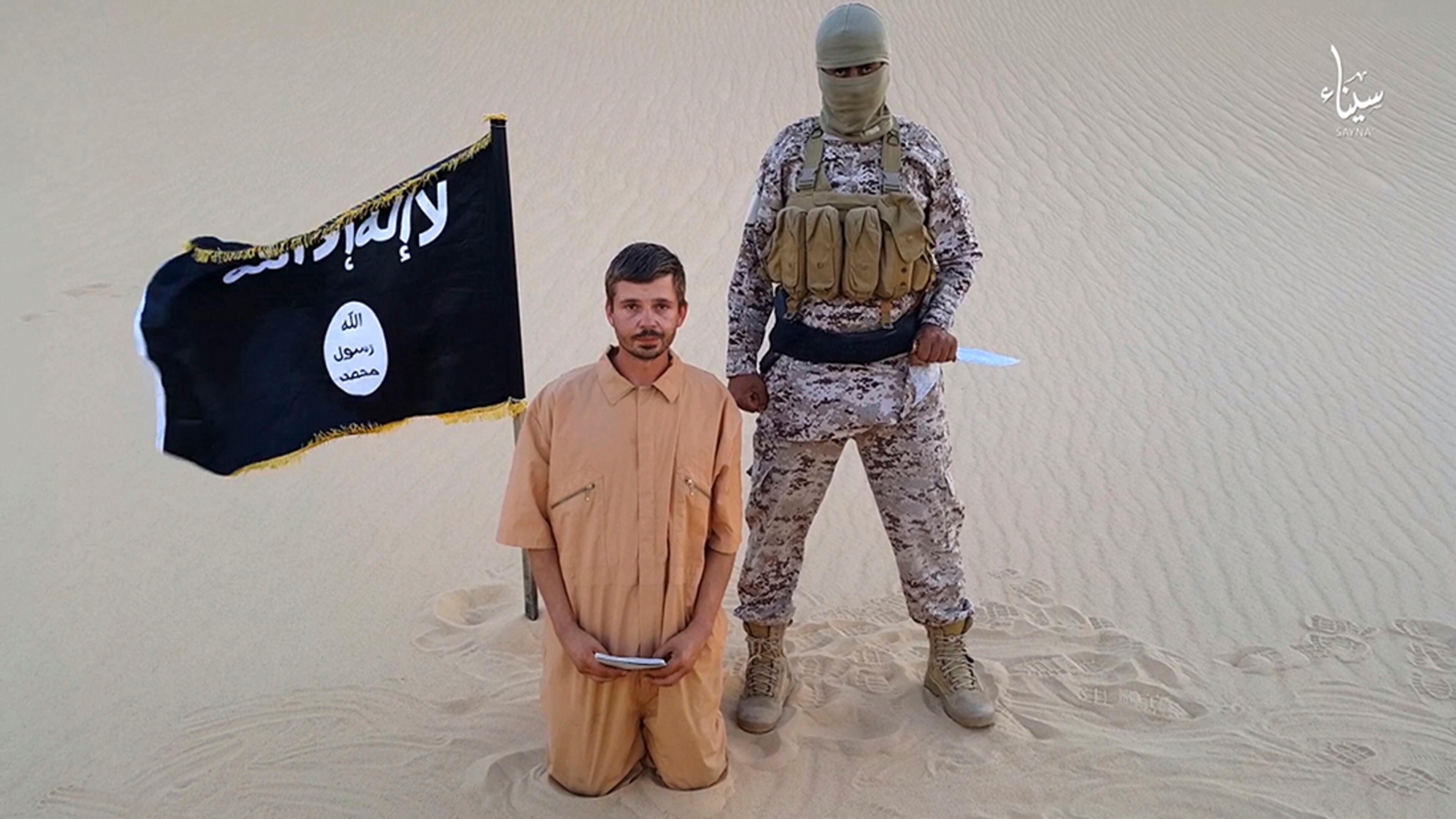 FILE - This image made from a militant video posted on a social media site on Wednesday, Aug. 5, 2015, which has been verified and is consistent with other AP reporting, purports to show a militant standing next to another man who identifies himself as 30-year-old Tomislav Salopek, kneeling down as he reads a message at an unknown location. An online image purports to show the Croatian hostage being held by an Islamic State affiliate in Egypt has been beheaded. (Militant video via AP, File)