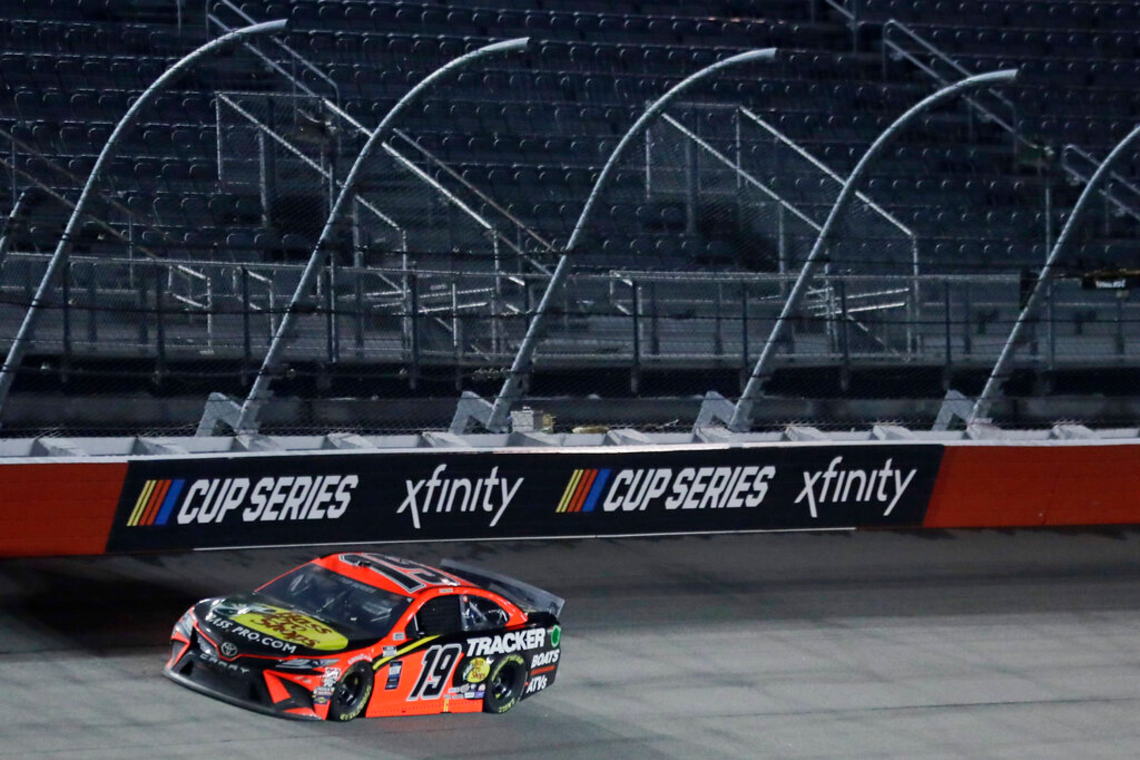 Martin Truex Jr. (19) drives past empty seats during the NASCAR Cup Series auto race Wednesday, May 20, 2020, in Darlington, S.C. (AP Photo/Brynn Anderson)