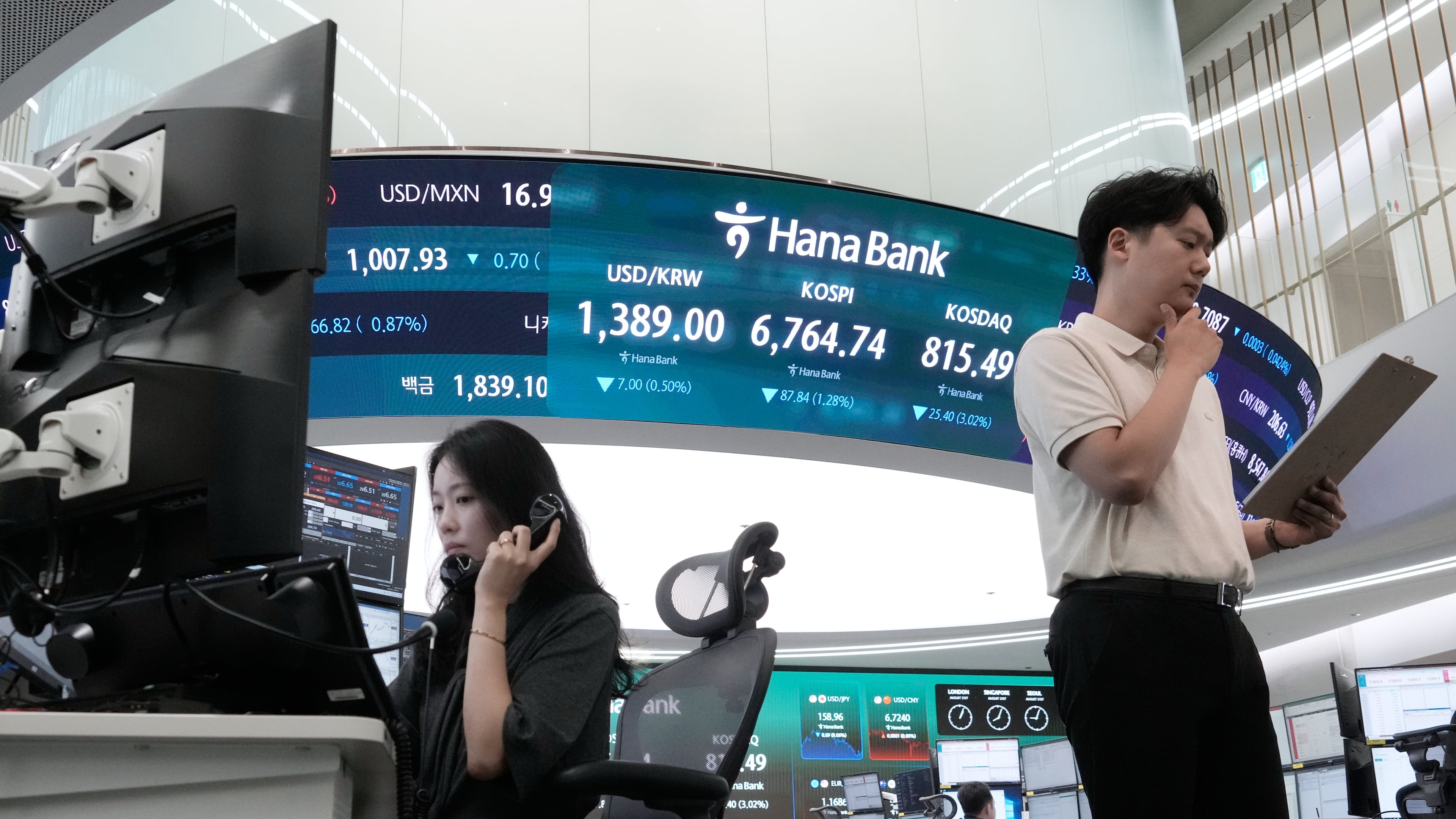 Currency traders work at the foreign exchange dealing room of the Hana Bank headquarters in Seoul, South Korea, Friday, Aug. 21, 2026. (AP Photo/Ahn Young-joon)