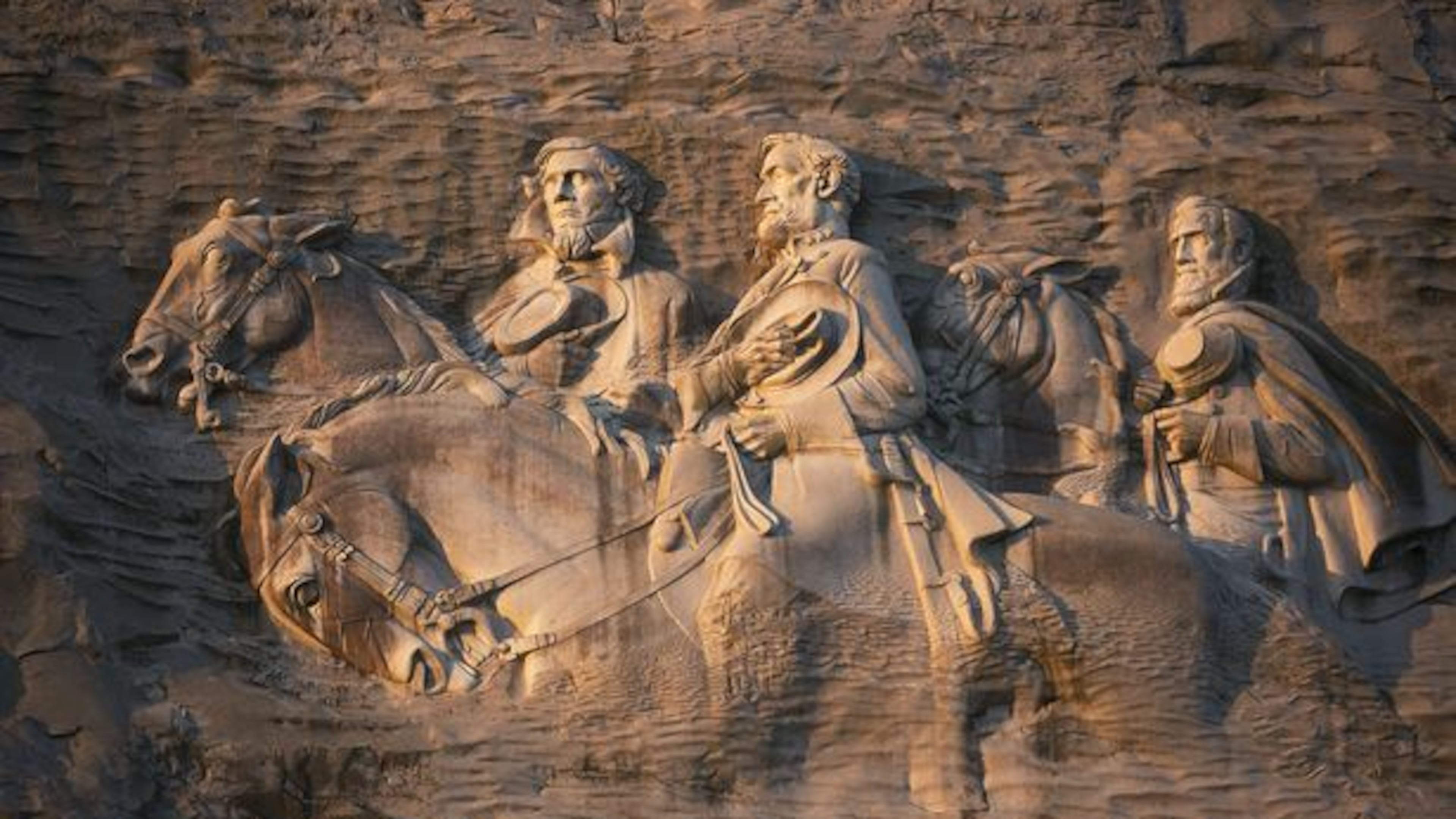 From left to right: Jeff Davis, Robert E. Lee and Stonewall Jackson carved into the side of Stone Mountain. (AJC File)