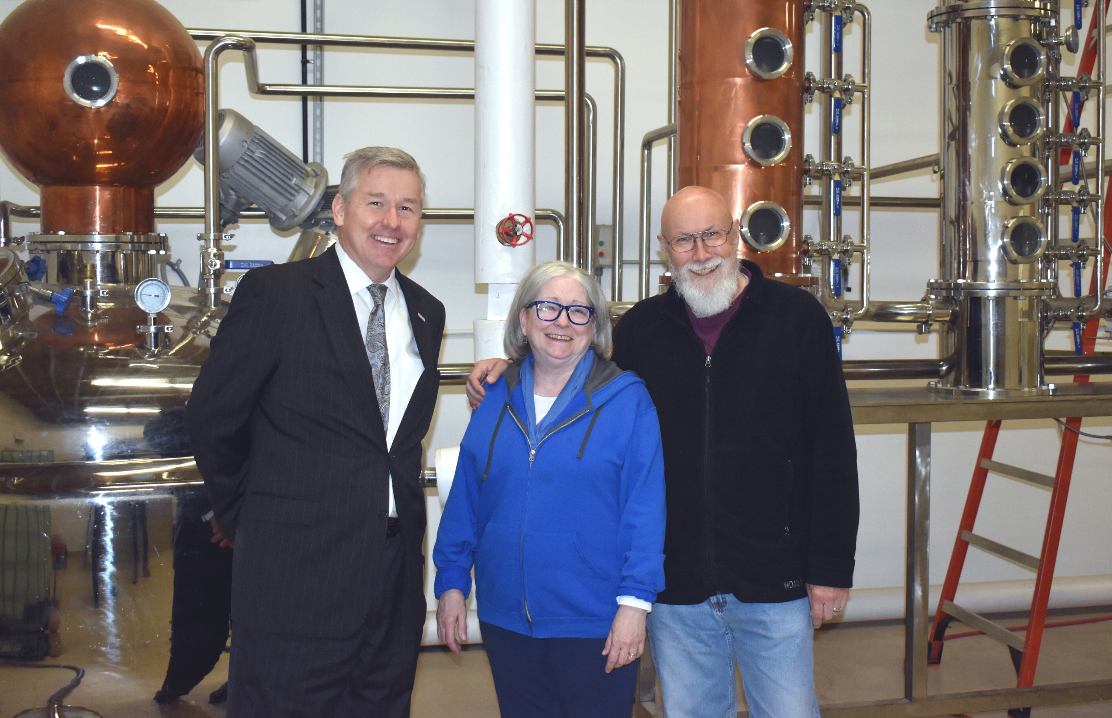 Hope Springs Distillery owners Paul Allen and Betsey Dahlberg pose with Congressman Rob Woodall at the distillery, where Allen and Dahlberg have been making hand sanitizer in addition to their distilled spirits. Courtesy of Hope Springs Distillery