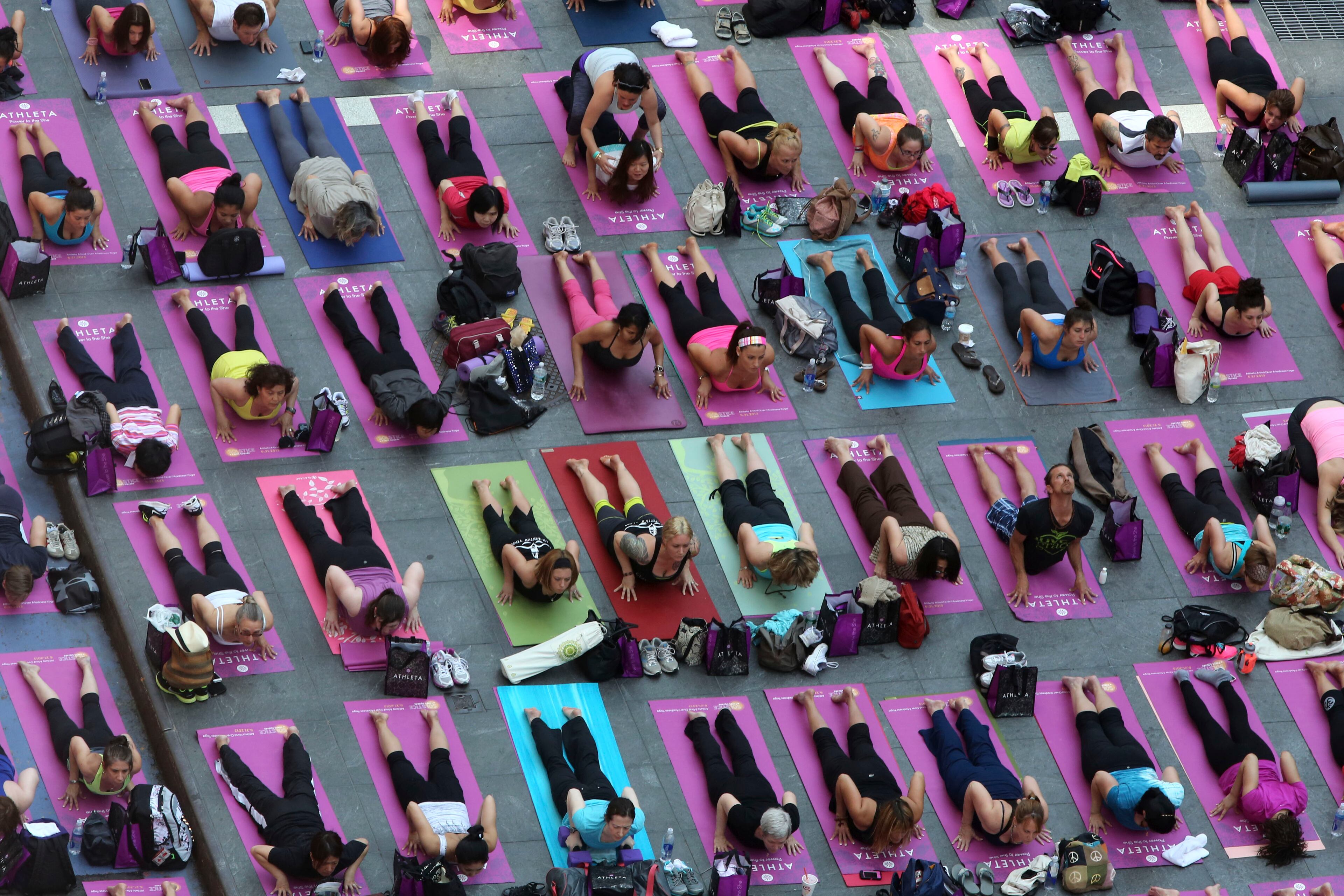 People practice yoga in New York's Times Square, Friday, June 21, 2013. Yoga enthusiast marked the longest day of the year with five free "Mind Over Madness" yoga classes in Times Square. (AP Photo/Mary Altaffer)