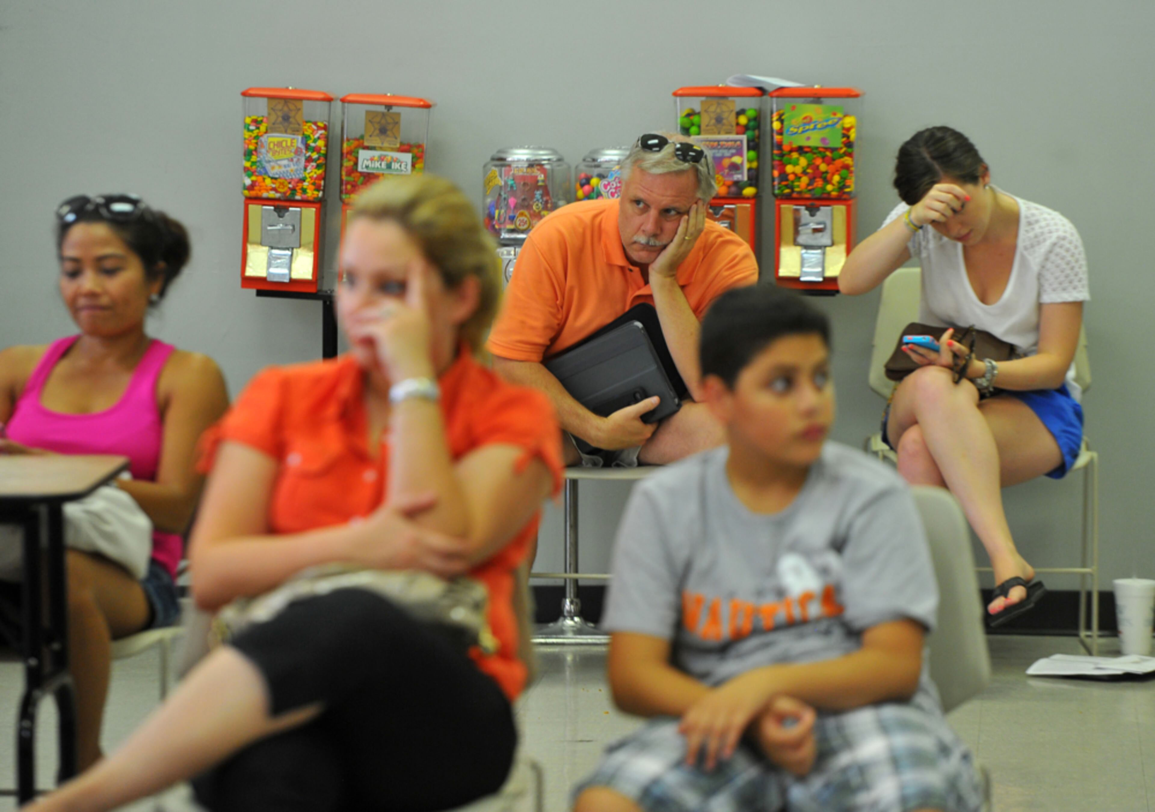 July 3,2012 Sandy Springs, GA:Peter Hardin and his daughter Jennie Hardin wait their turn at the Department of Drivers Services Sandy Springs office Tuesday July 3, 2012. A new rule requiring renewals be done in person, new ID requirements, and the July 4th Holiday combined to make the process take just under 6 hours for many at the Sandy Springs DDS office. I was sent to the DDS office after complaints of long lines started coming in. It wasn't hard to find tired and frustrated people. BRANT SANDERLIN / BSANDERLIN@AJC.COM