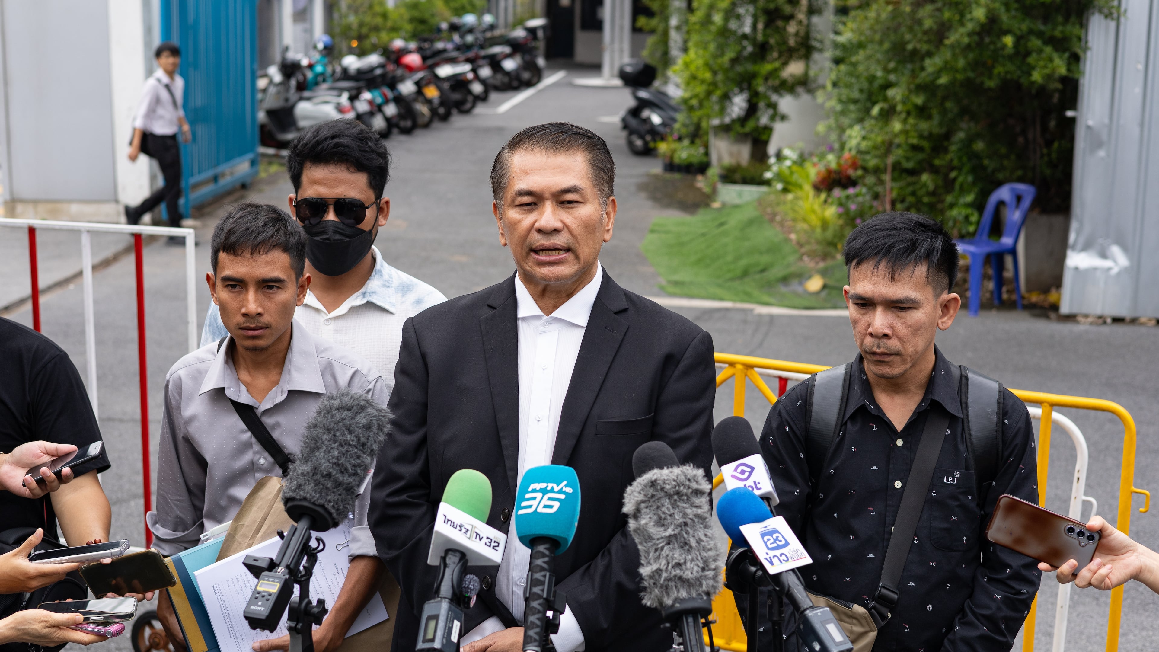 Lawyer Kunpat Singhathong and three sailors from the Thailand-flagged ship, the Mayuree Naree, speak to journalists outside the Central Labour Court in Bangkok, Thailand on Friday, July 10, 2026. (AP Photo/Anton L. Delgado)