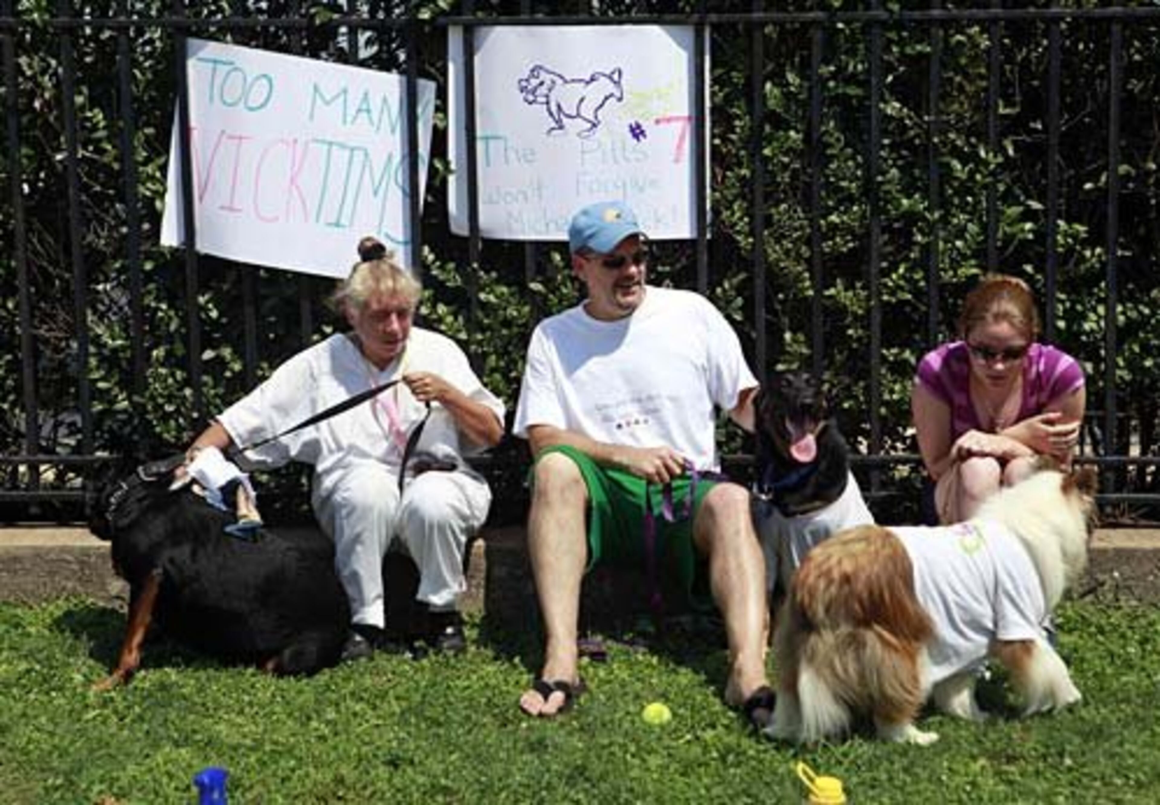 Elly Scoblink (left) with her dog Rockett, Rob Bedford and his dog Raven, along with his daughter Chelsea, 15, and her dog Tex, all of Philadelphia, protest outside the Eagles NFL football practice facility in Philadelphia, Saturday, Aug. 15.