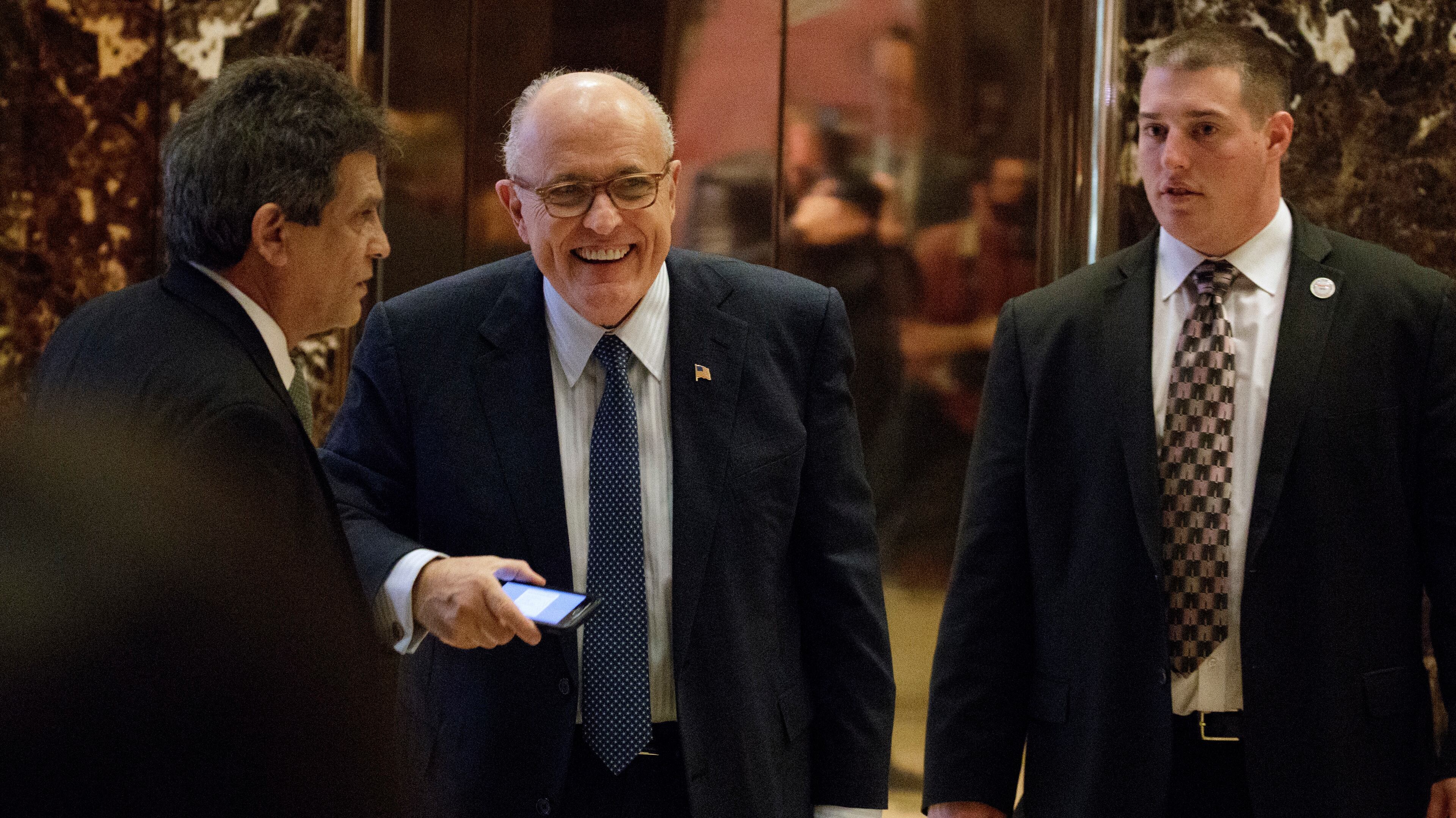 Former New York Mayor Rudy Giuliani, center, smiles as he leaves Trump Tower, Friday, Nov. 11, 2016, in New York. (AP Photo/Evan Vucci)