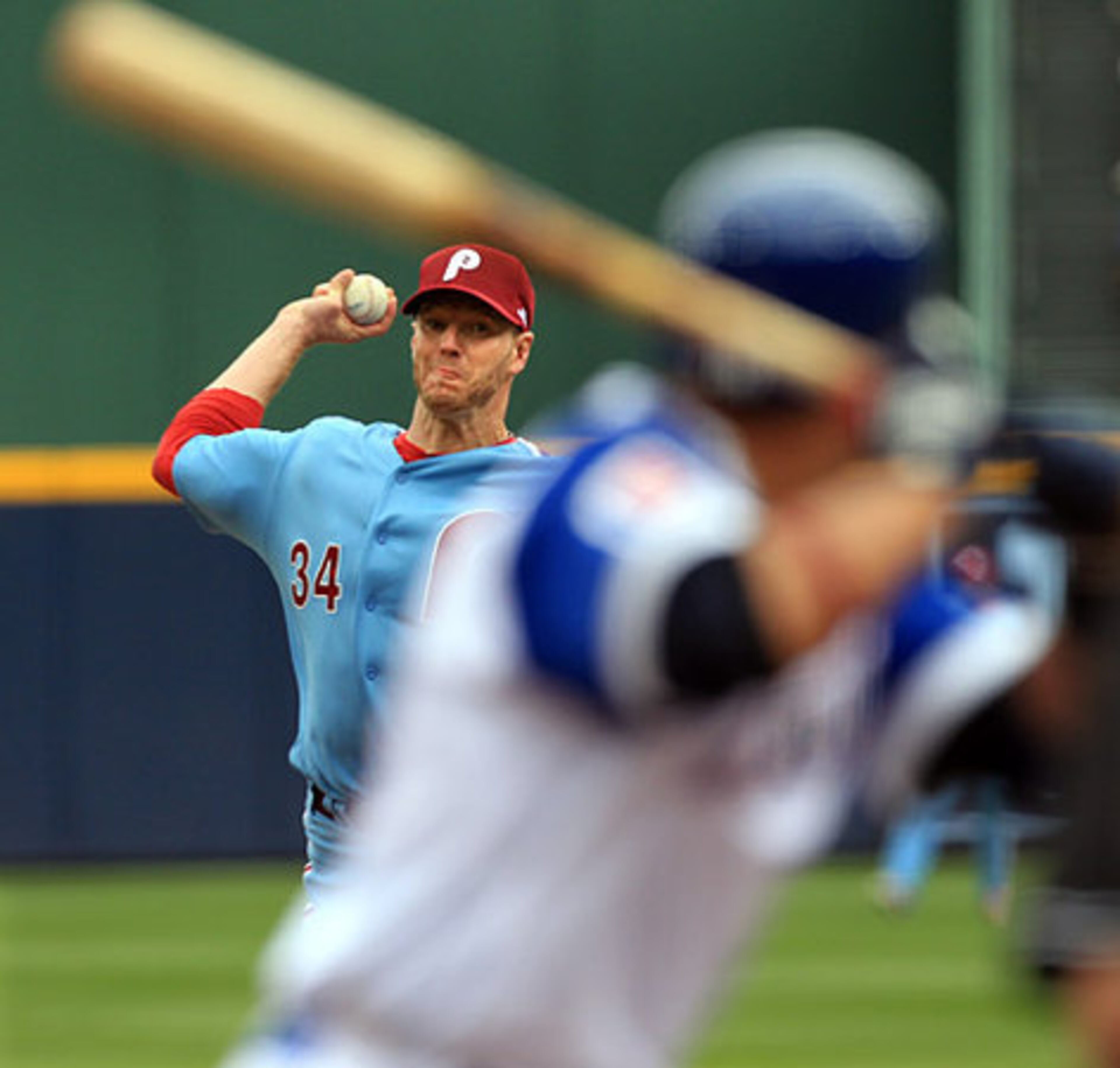 Phillies pitcher Roy Halladay, wearing the 1974-style uniform, delivers a pitch to the Braves' Martin Prado.