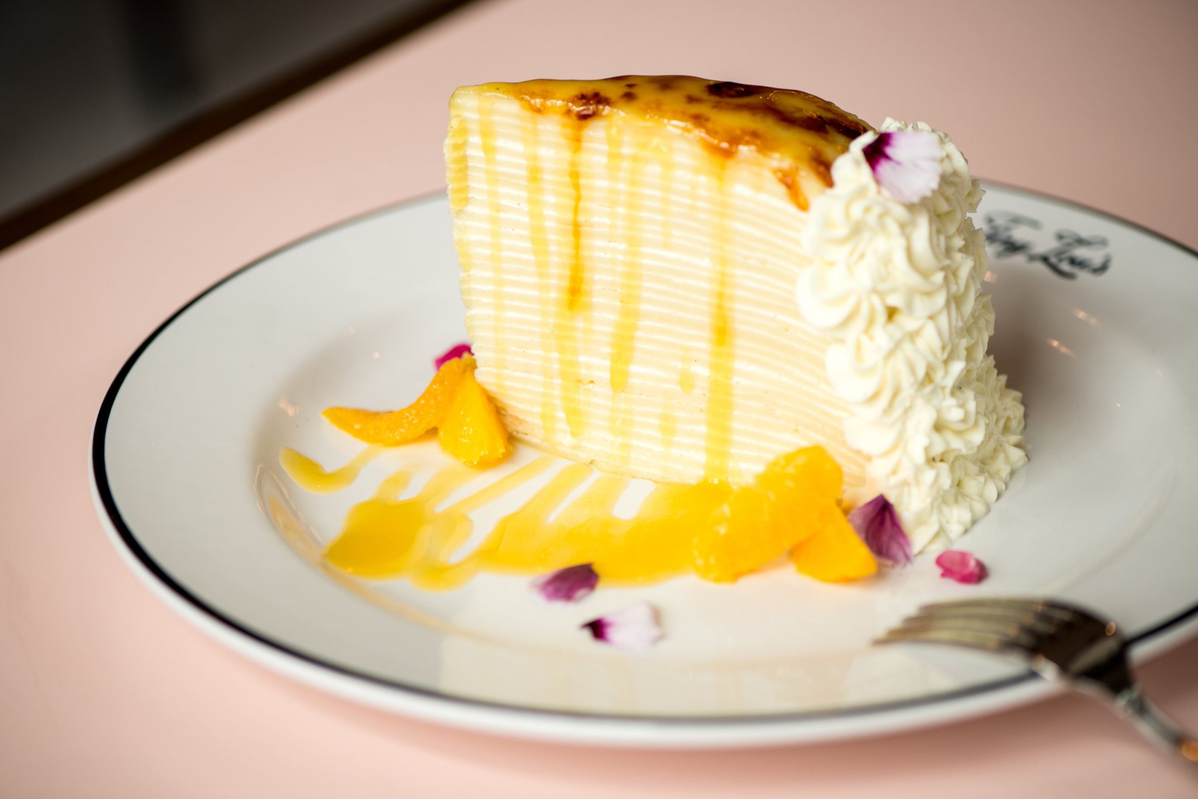 Crepe Suzette Cake dessert with thin French crepes, orange cream, warm beurre suzette, and citrus. Photo credit- Mia Yakel.