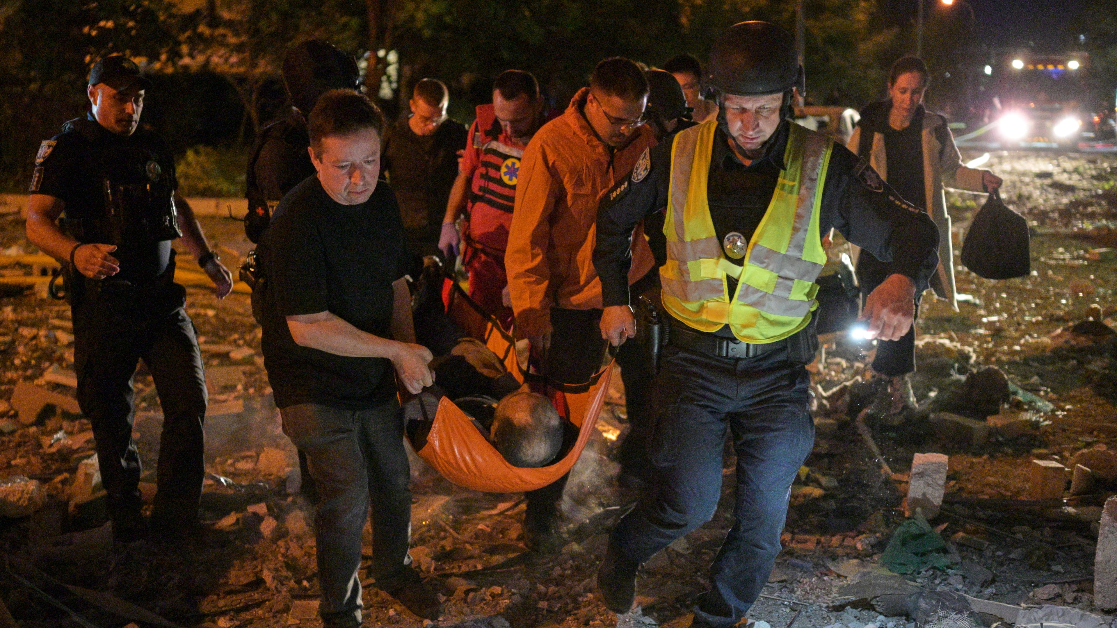 Emergency workers carry an injured person following Russian missile attacks in Kyiv, Ukraine, Monday, July 6, 2026. (AP Photo/Danylo Antoniuk)