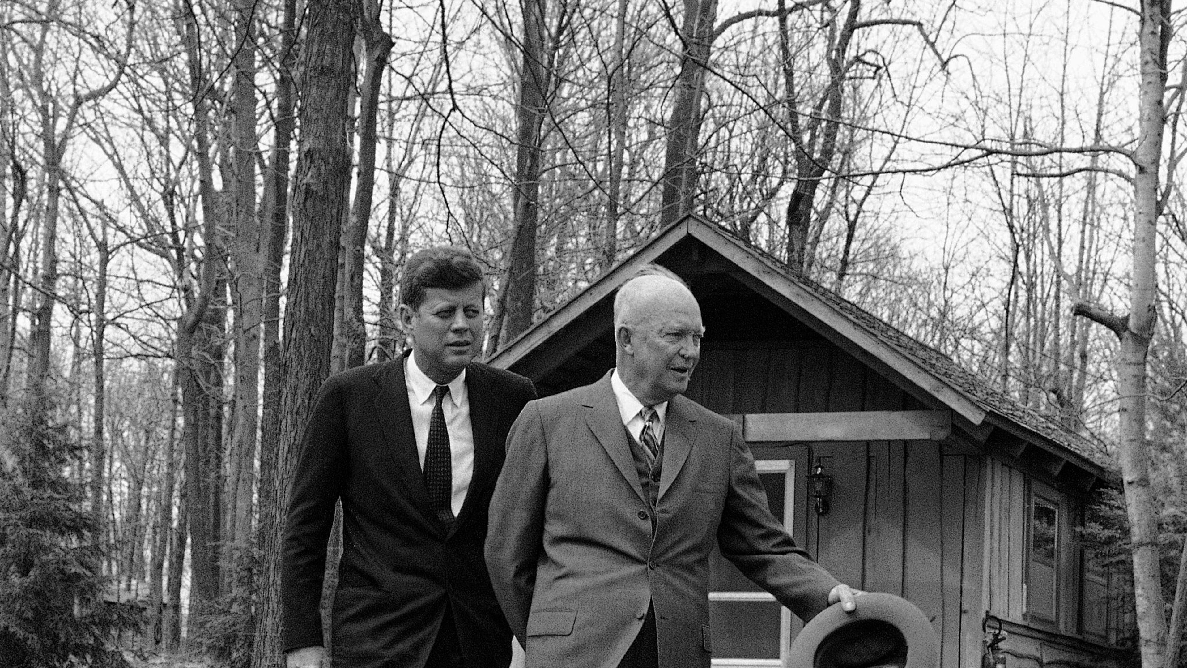 FILE - President John Kennedy and former President Dwight Eisenhower walks along a flagstone path, in perfect step at Camp David, atop of mountain near Thurmont, Maryland on April 22, 1961 after they flew there to discuss the Cuban crisis. In background is one of the lodges at the camp. (AP Photo, File)