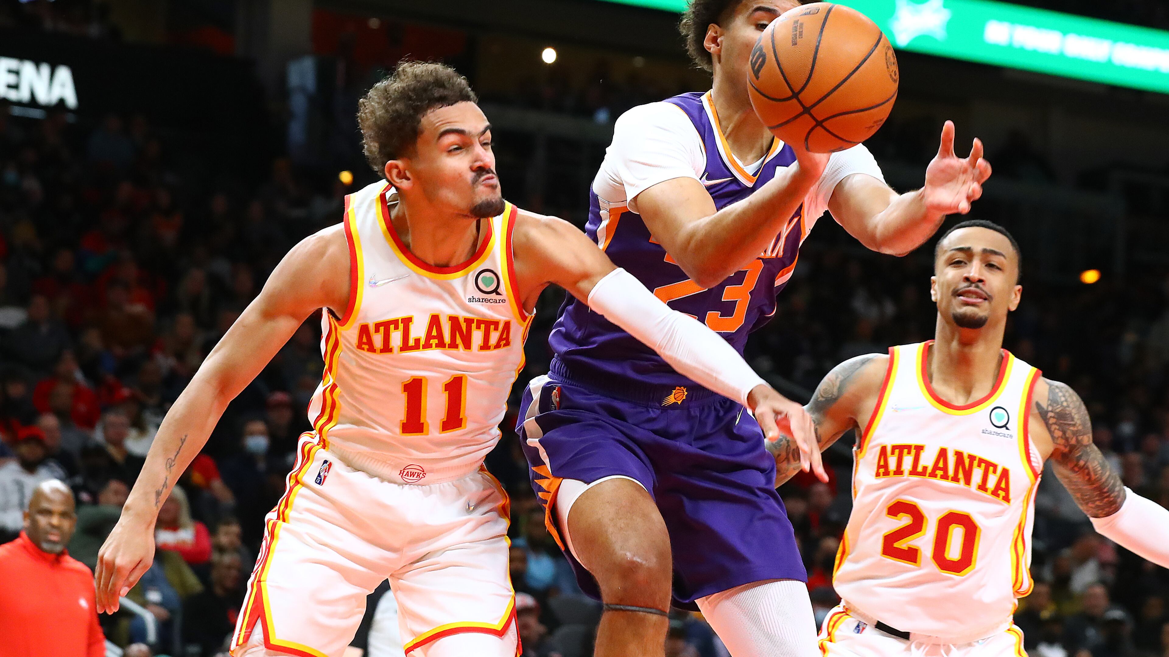 020322 Atlanta: Atlanta Hawks guard Trae Young knocks the ball away from Phoenix Suns forward Cam Johnson with John Collins looking on during the first half of a NBA basketball game on Thursday, Feb. 3, 2022, in Atlanta. “Curtis Compton / Curtis.Compton@ajc.com”`