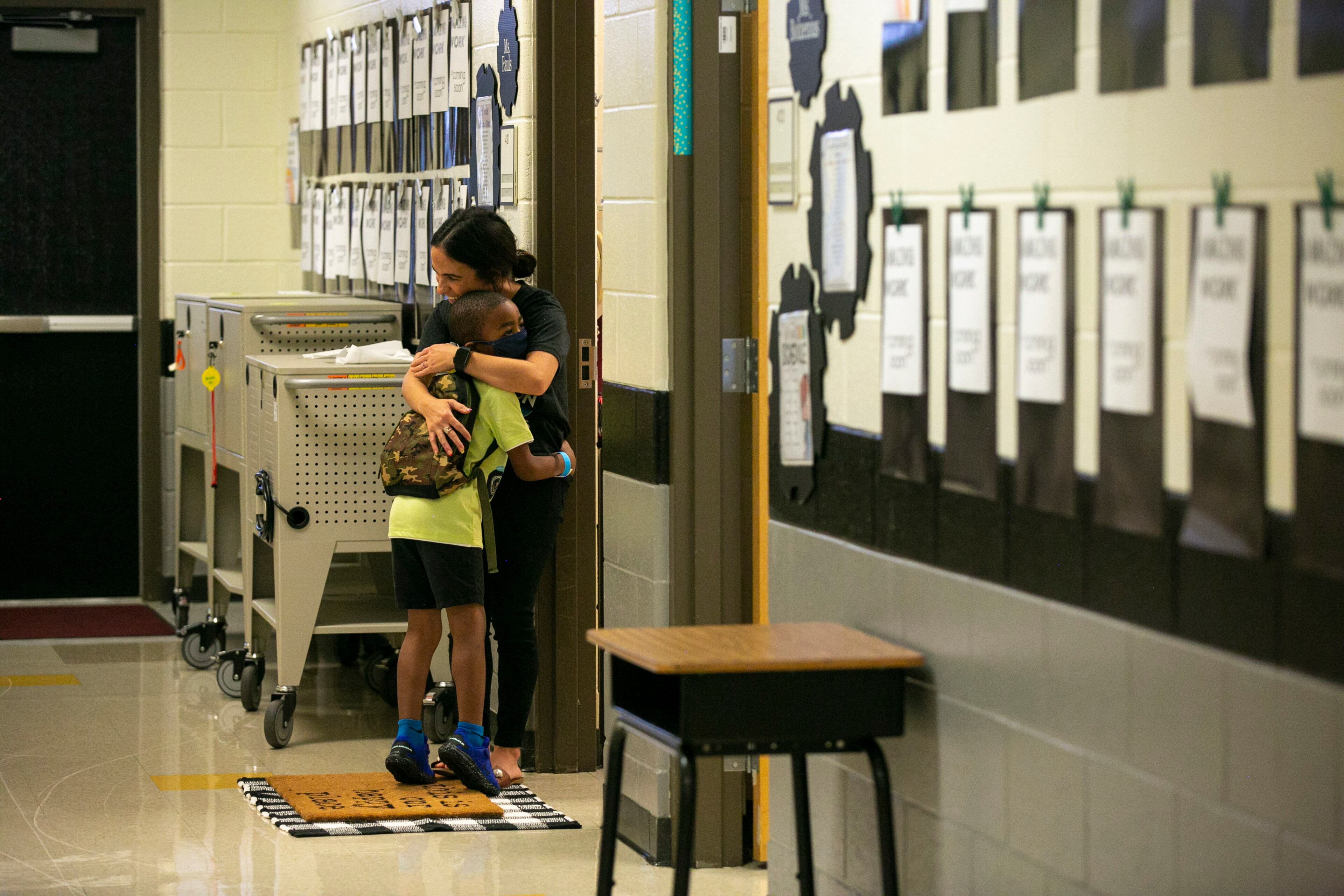 First grade teacher Ms. Fauls greets a new student with a hug on the first day of school at Clark Creek Elementary School in Acworth, Georgia, on August 2, 2021. (Rebecca Wright for the Atlanta Journal-Constitution)