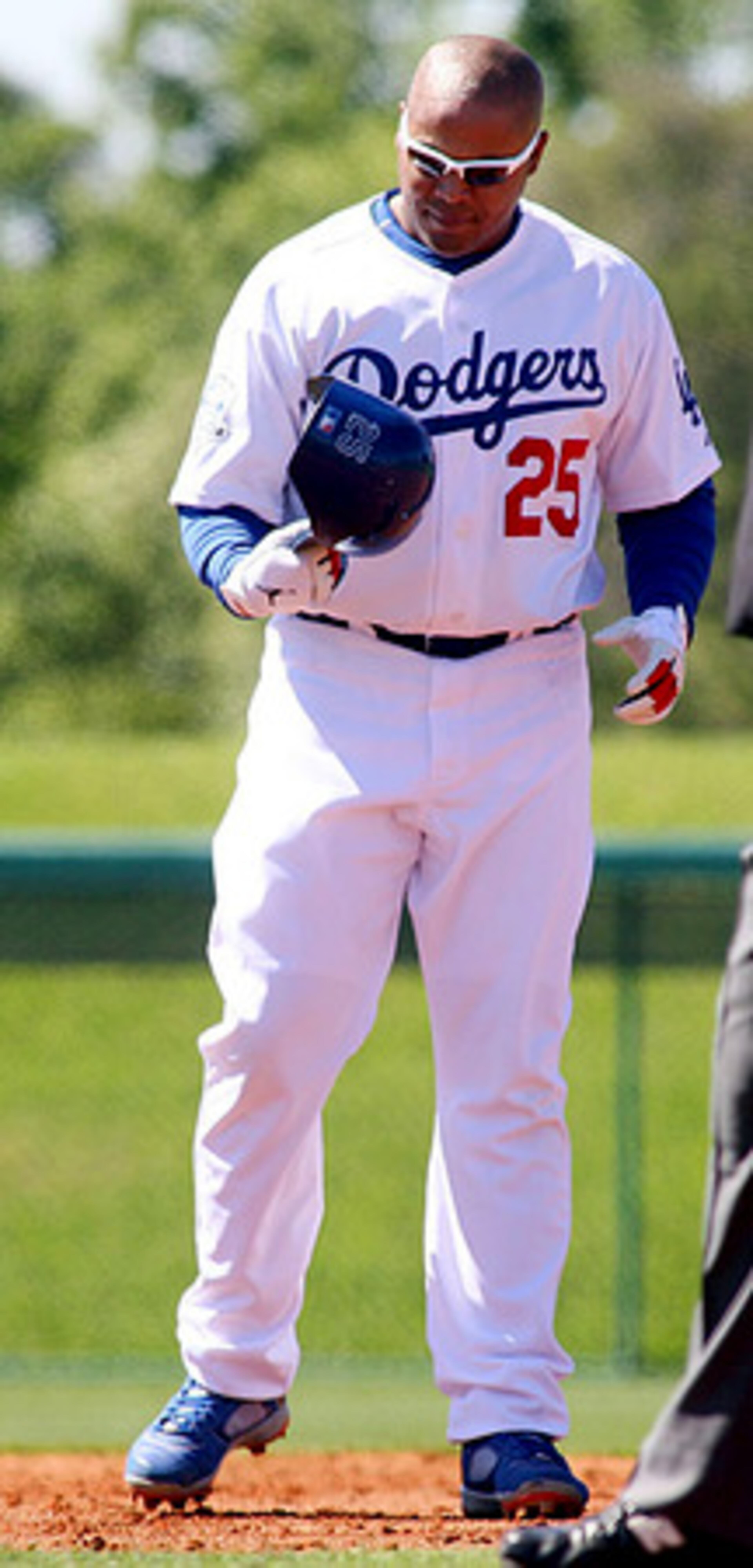 Former Brave Andruw Jones, who signed a two-year deal with the Dodgers this offseason, checks his helmet at second base during a break in the action. He drew two walks and scored a run in his first action as a Dodger.