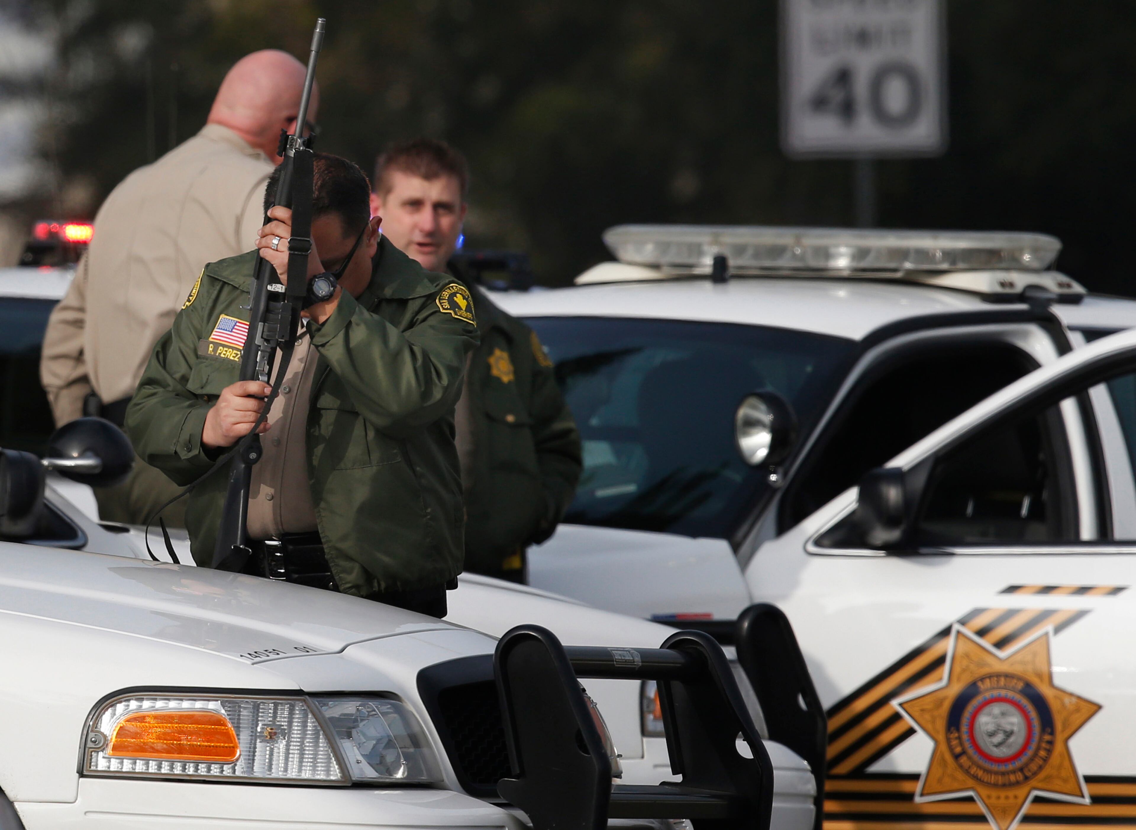 A San Bernardino County sheriff's deputy stands guard near the area where a shooting took place in Riverside, Calif, Thursday, Feb. 7, 2013. Police launched a massive manhunt for a former Los Angeles officer.