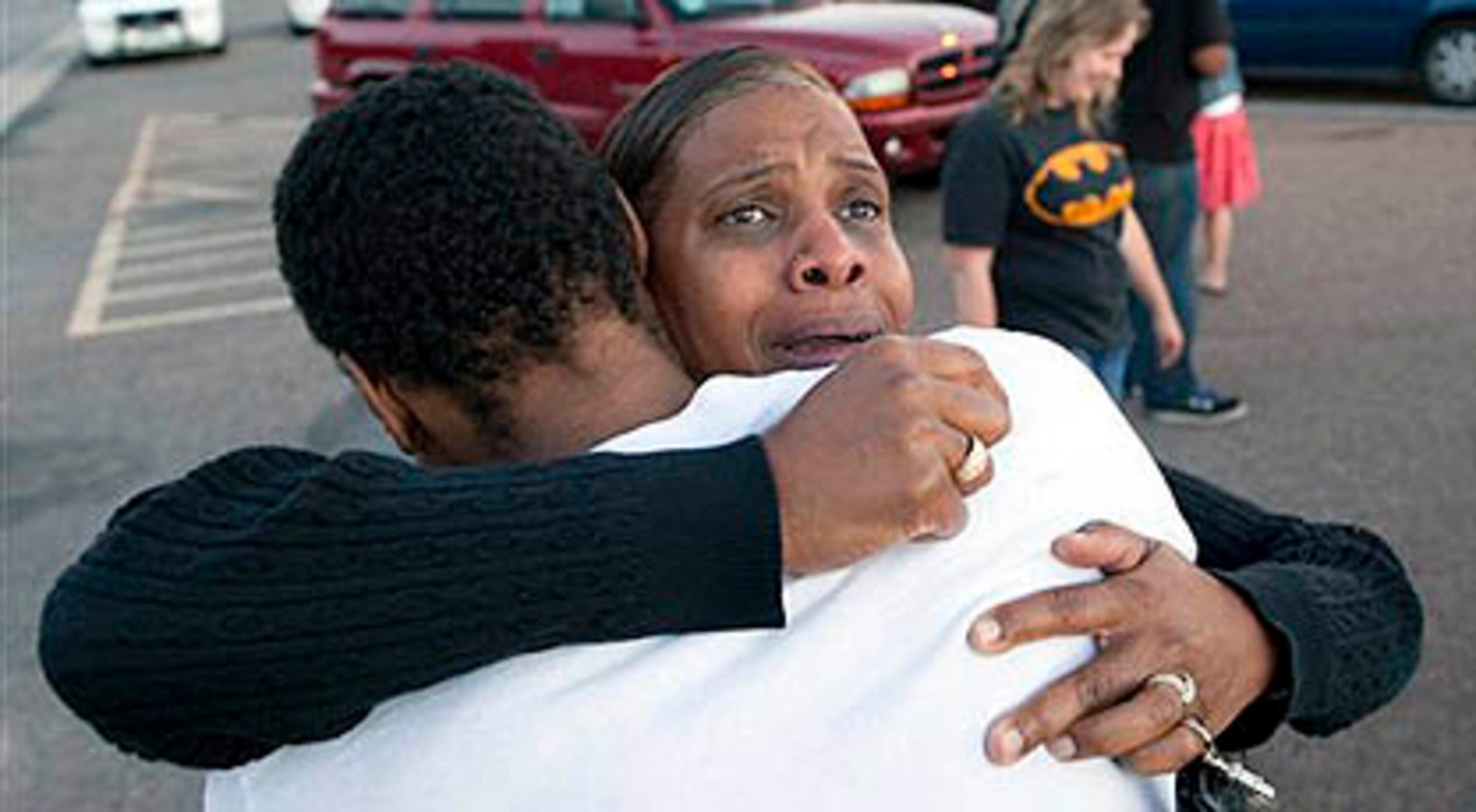 Shamecca Davis hugs her son Isaiah Bow, who was an eye witness to the shooting, outside Gateway High School where witness were brought for questioning Friday, July 20, 2012 in Denver. After leaving the theater Bow went back in to find his girlfriend. " I didn't want to leave her in there. But she's ok now," Bow said. A gunman wearing a gas mask set off an unknown gas and fired into a crowded movie theater at a midnight opening of the Batman movie "The Dark Knight Rises," killing at least 12 people and injuring at least 50 others, authorities said. (AP Photo/Barry Gutierrez)