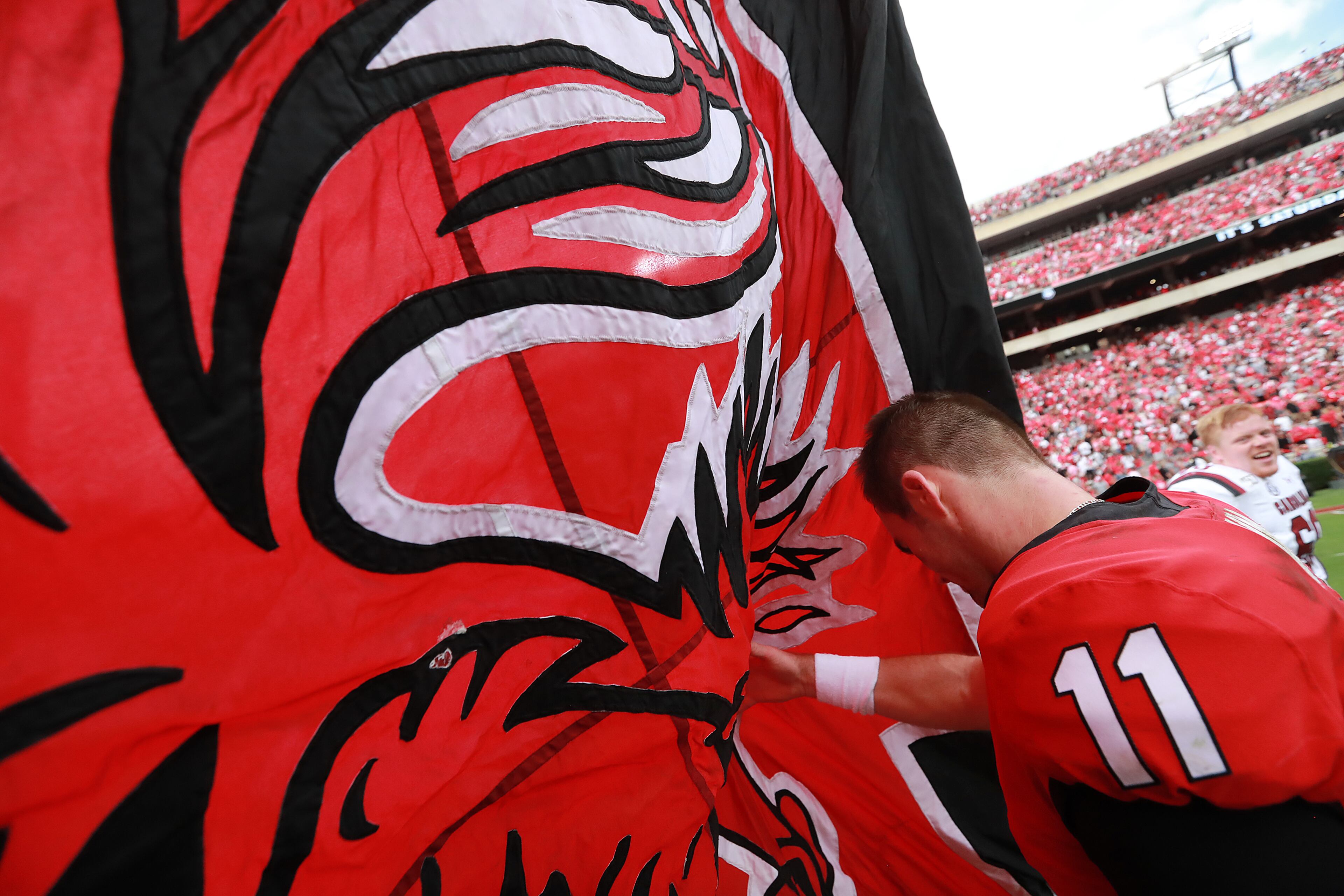 Georgia quarterback Jake Fromm is wrapped up in the South Carolina Gamecock flag as he walks off the field. Curtis Compton/ccompton@ajc.com