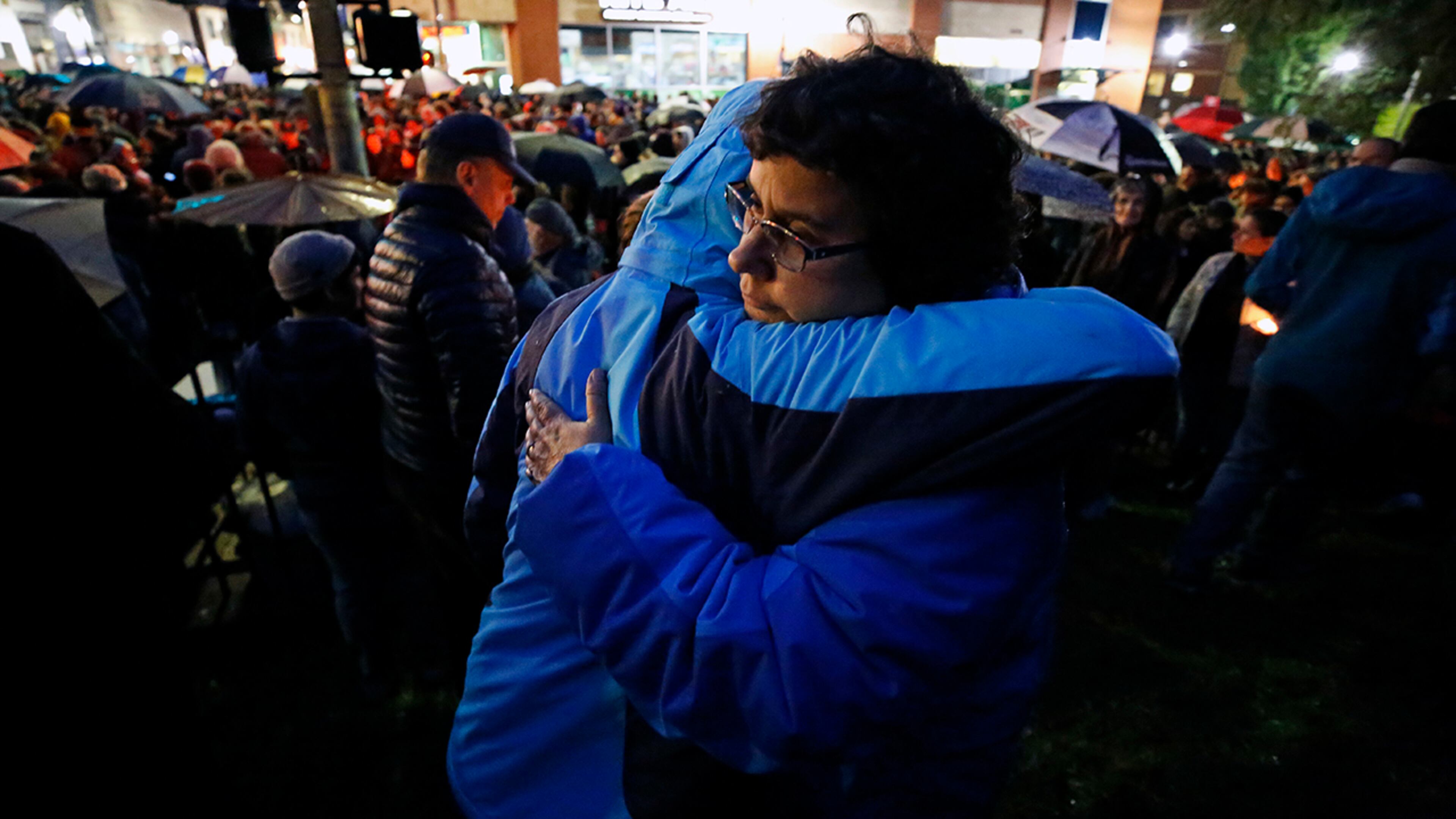 Amy Gilligan hugs her daughter at the intersection of Murray Avenue and Forbes Avenue in the Squirrel Hill section of Pittsburgh, during a memorial vigil for the victims of the shooting at the Tree of Life Synagogue where a shooter opened fire, killing multiple people and wounding others, including several police officers, Saturday, Oct. 27, 2018. (AP Photo/Gene J. Puskar)