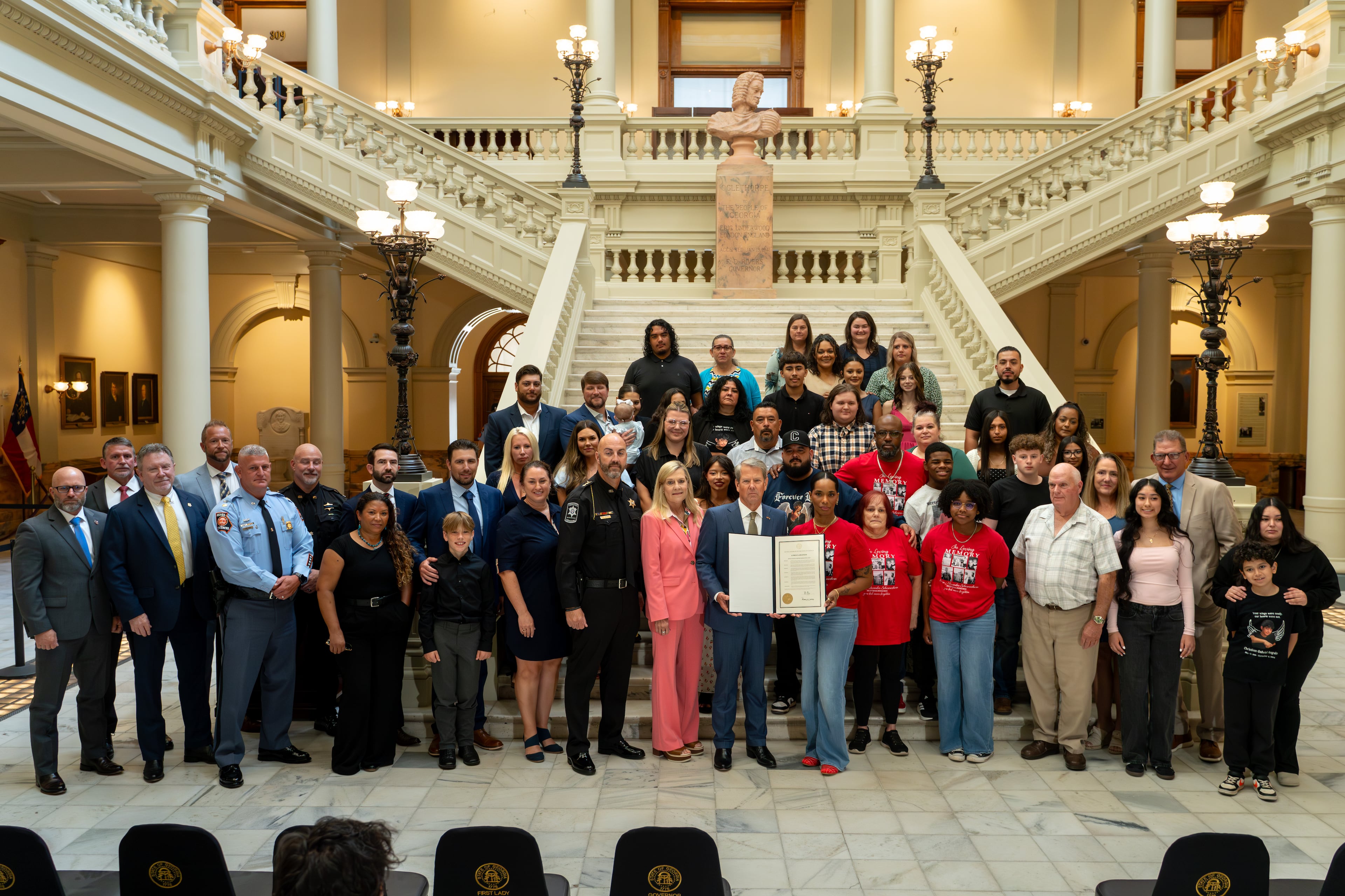 Gov. Brian Kemp, Barrow County officials and victims' family members at Thursday's ceremony. (Ben Hendren/AJC)
