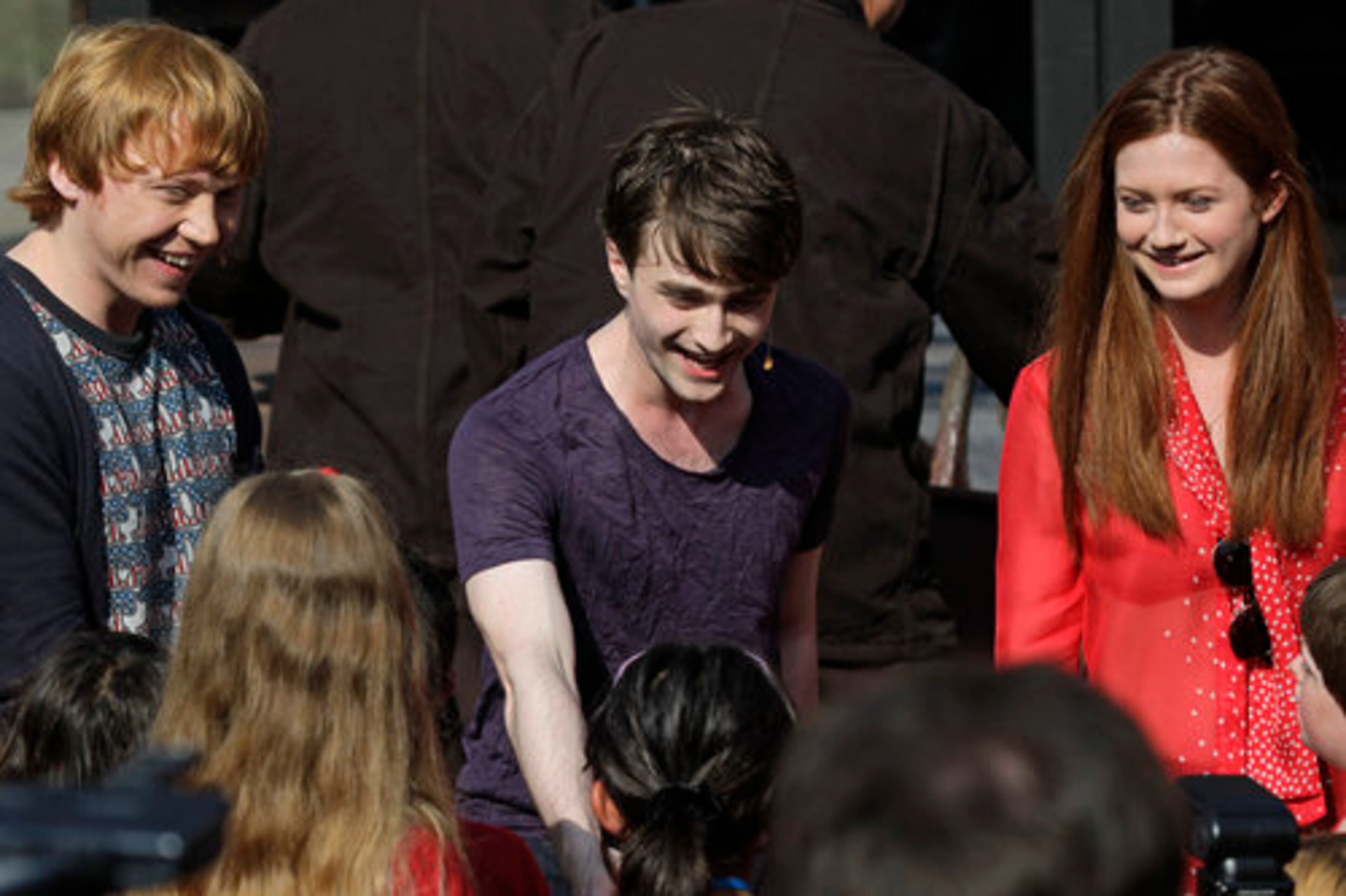Members of the cast of the Harry Potter films, from left, Rupert Grint, Daniel Radcliffe and Bonnie Wright, greet fans during the grand opening.