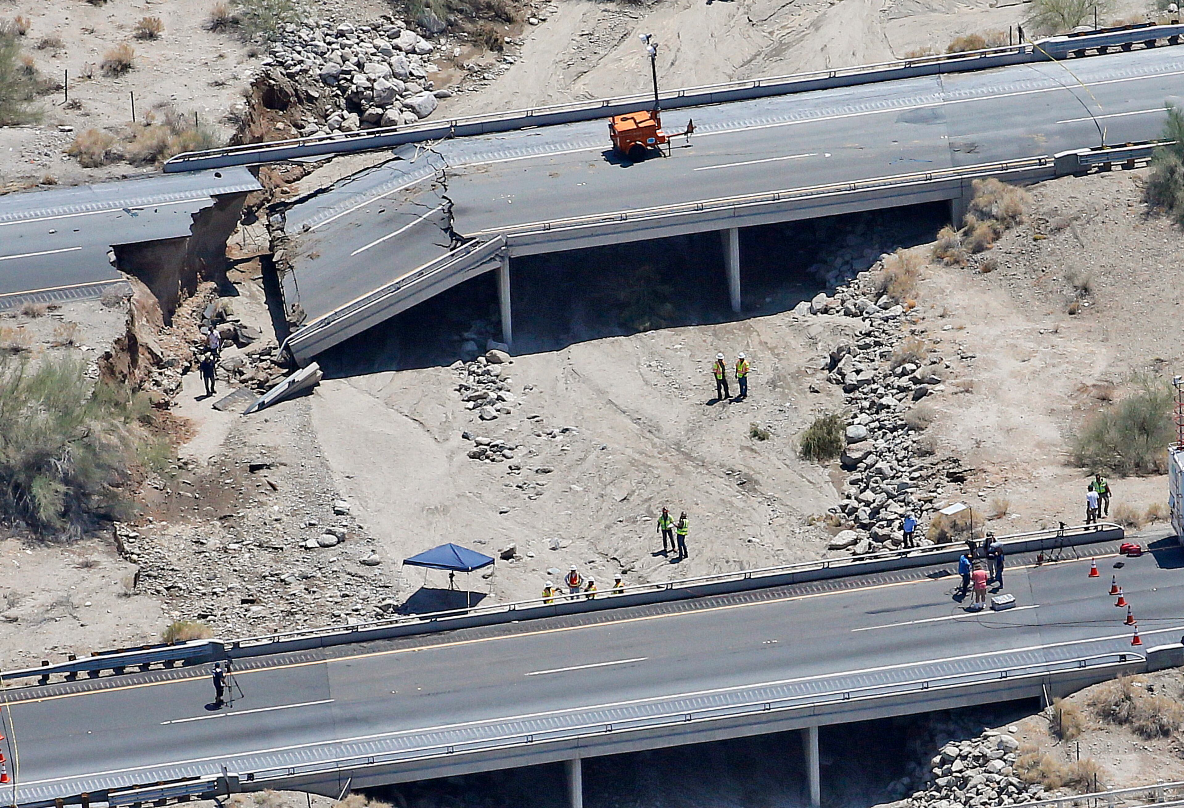 A collapsed elevated section of Interstate 10 is seen from the air, Monday, July 20, 2015, in Desert Center, Calif. All traffic along one of the major highways connecting California and Arizona was blocked indefinitely when the bridge over a desert wash collapsed during a major storm, and the roadway in the opposite direction sustained severe damage. (AP Photo/Matt York)