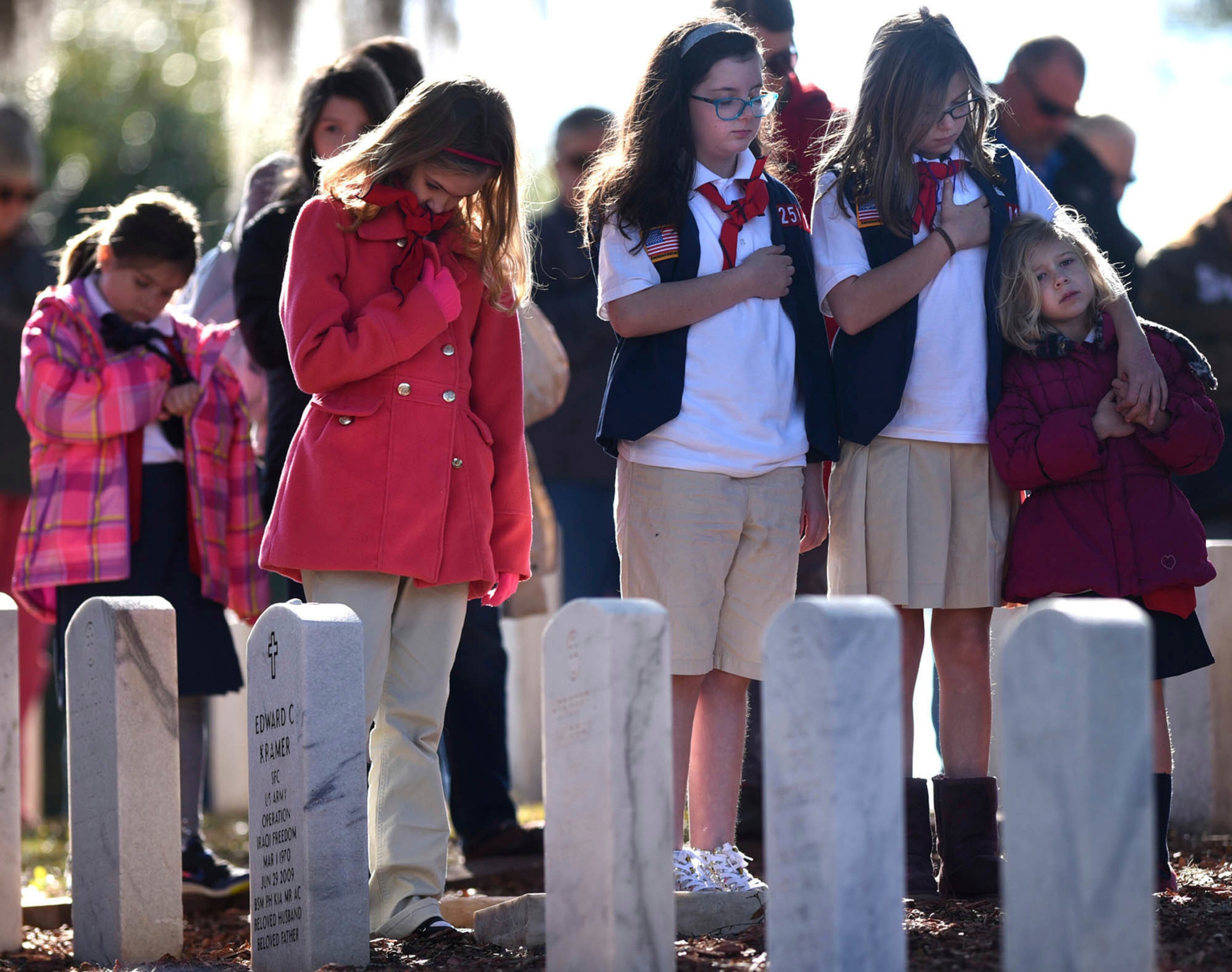People stand during The Pledge of Allegiance at the annual Wreaths Across America event at Wilmington National Cemetery in Wilmington, N.C. Saturday, Dec.16, 2017. More than 5,000 wreaths were placed on headstones across the cemetery. The program is carried out nationally every December at Arlington National Cemetery, as well as over 1,200 additional locations in all 50 U.S. states, at sea, and abroad. (Matt Born/The Star-News via AP)