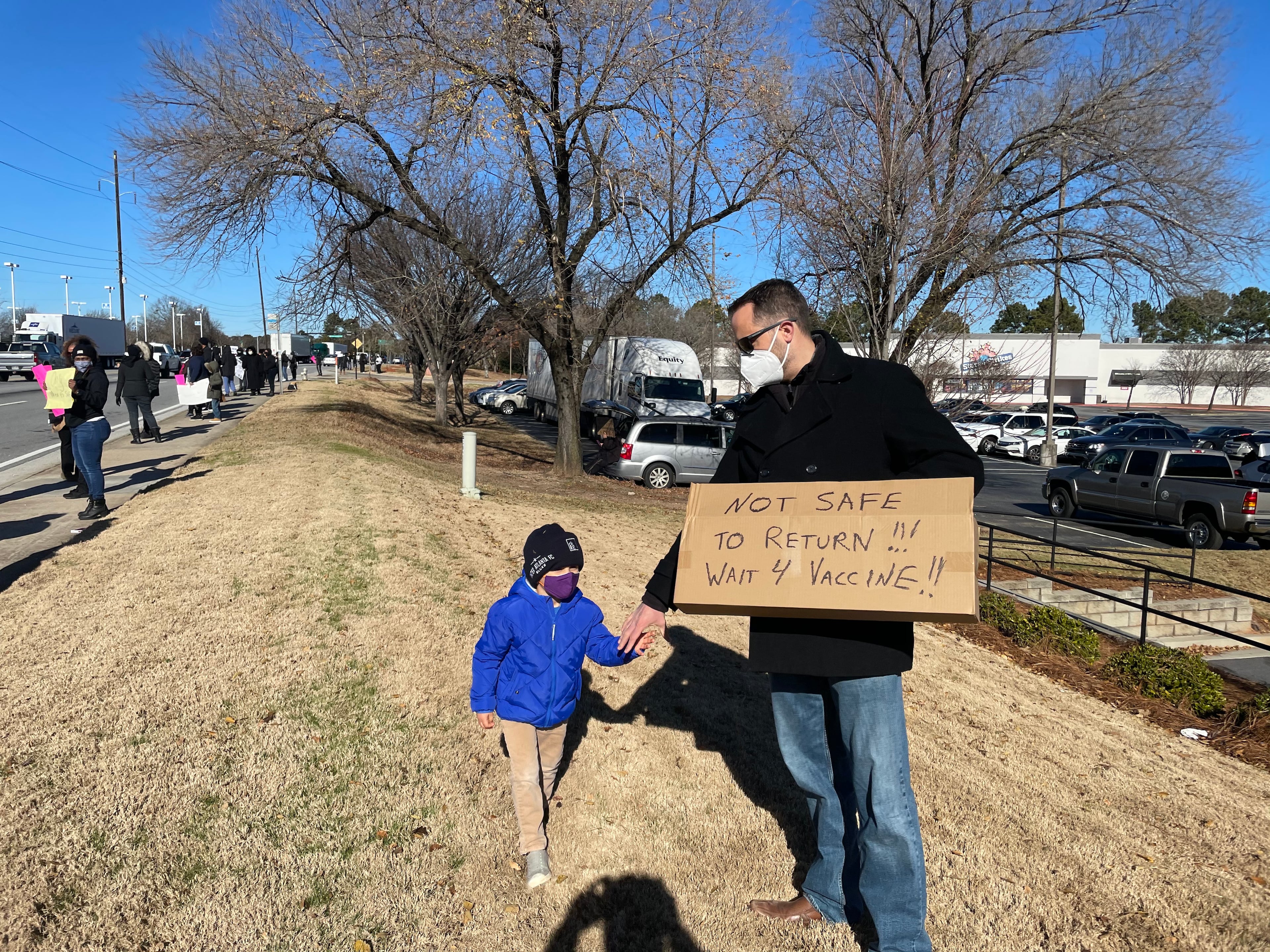 DeKalb County math teacher Josh Weddle attended the protest with his son, Lincoln, because he thinks coronavirus infection cases "are way too high for schools to reopen right now."