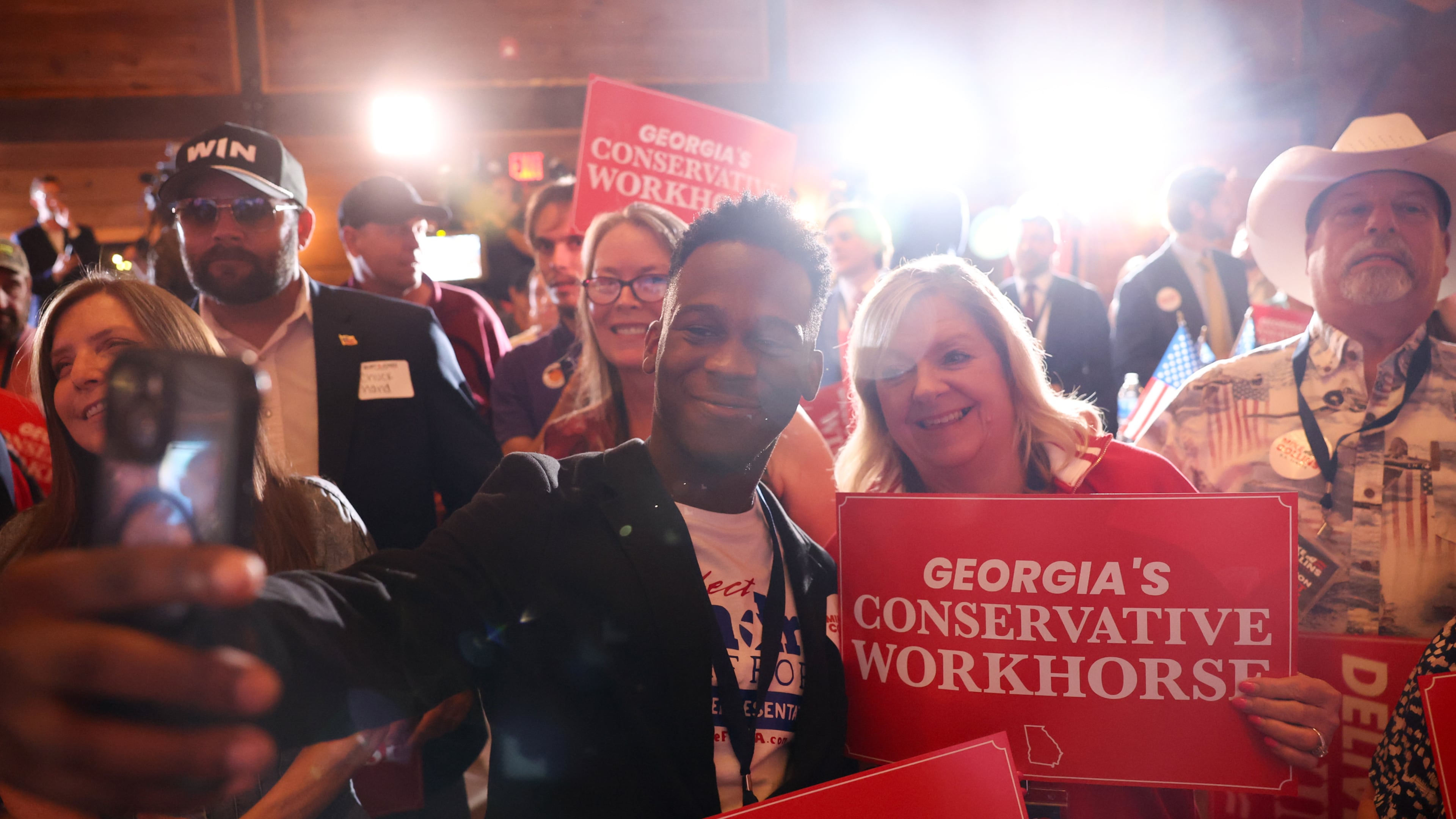 Republican State House candidate Andre Stafford (center) takes a selfie while waiting for Republican U.S. Senate candidate Mike Collins to speak at his primary election watch party at The Carmichael House in Jackson on May 19, 2026. Stafford was arrested in Cobb County on Thursday and charged with exposing himself to a minor child. He was released on bond. (Arvin Temkar/AJC)
