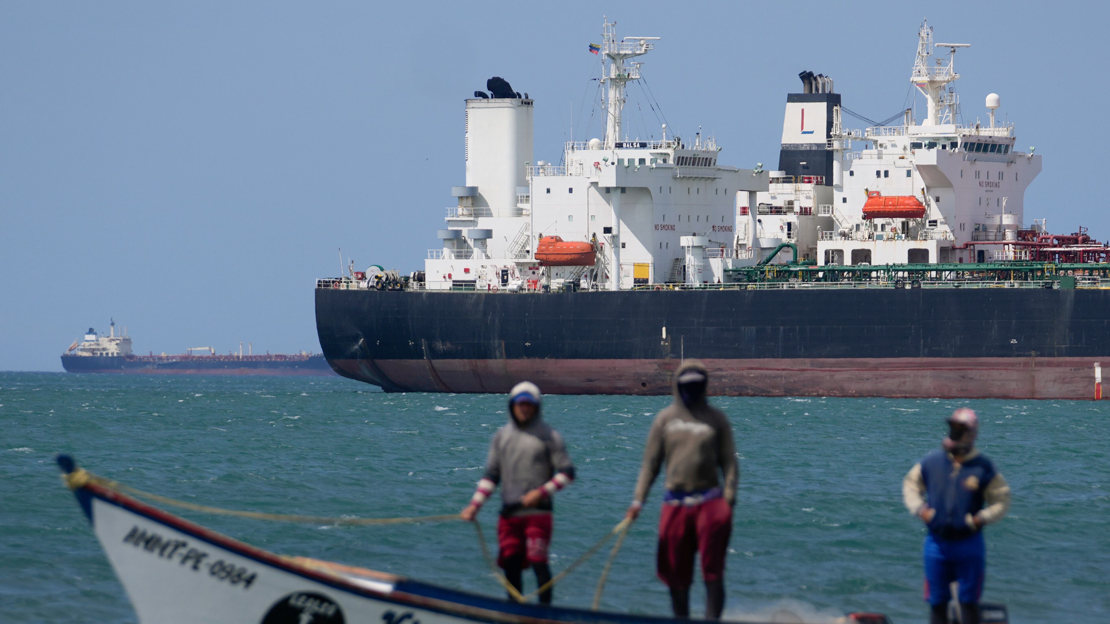 FILE - Fishermen pass an oil tanker in the Gulf of Venezuela off the shore of Punta Cardon, Venezuela, Jan. 14, 2026. (AP Photo/Matias Delacroix, FIle)