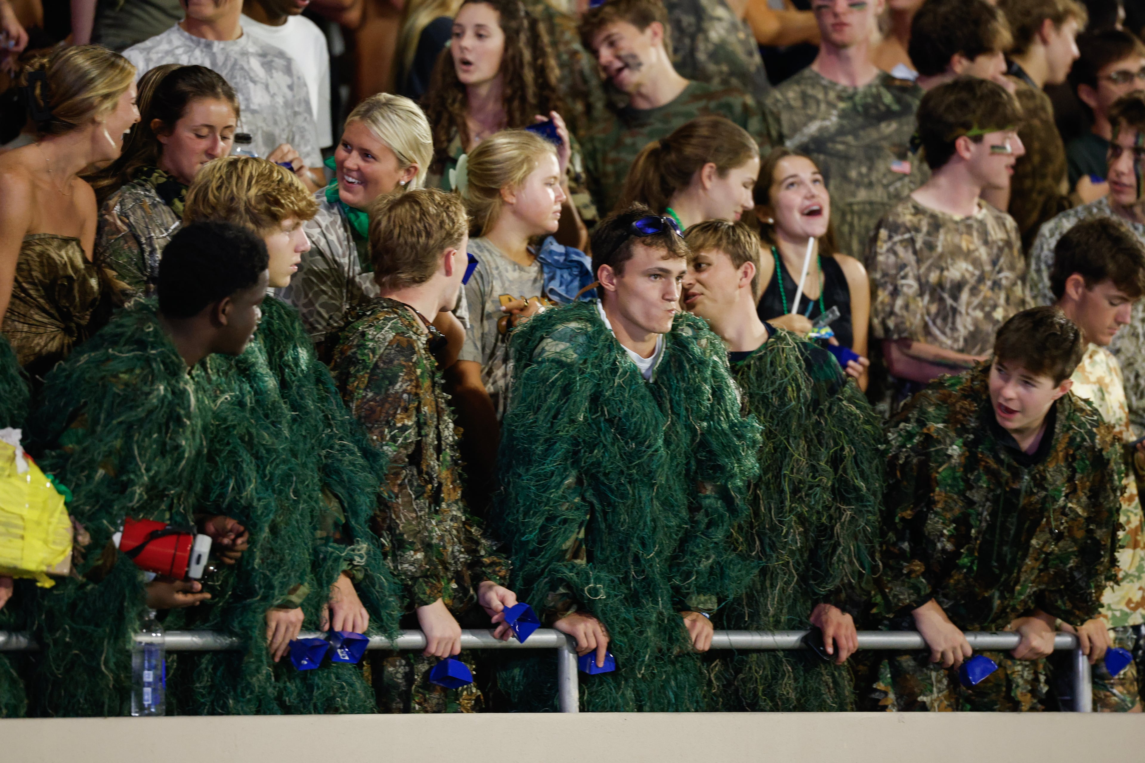Marist students dressed in camouflage watch as their team battles against Blessed Trinity on Friday, Sept. 25, 2026, in Atlanta. (Erik S. Lesser for the AJC)