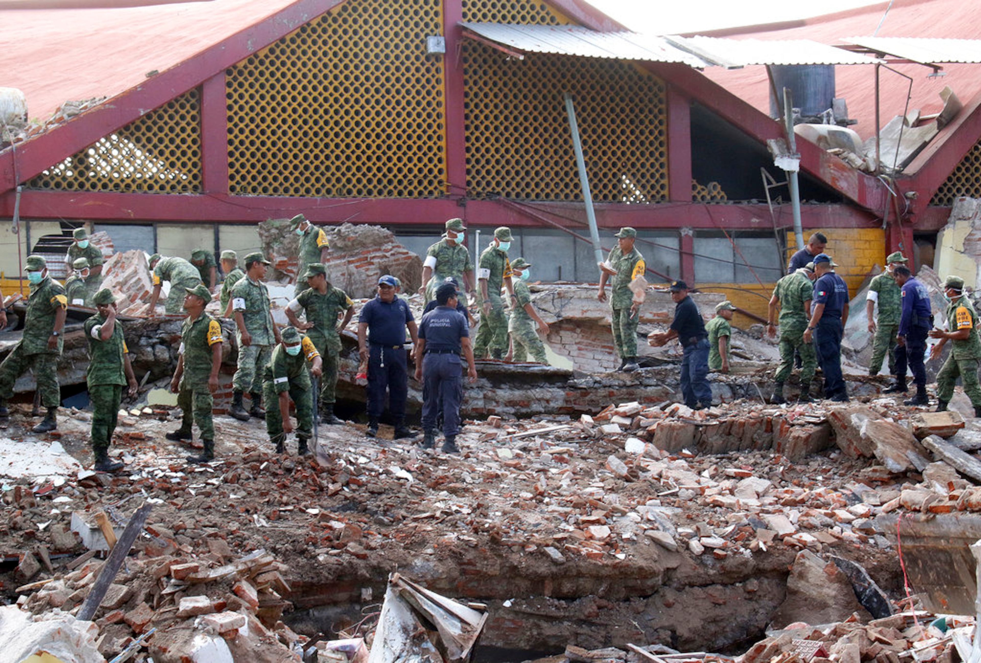 Soldiers remove debris from a partly collapsed municipal building felled by a massive earthquake in Juchitan, Oaxaca state, Mexico, Friday, Sept. 8, 2017. One of the most powerful earthquakes ever to strike Mexico has hit off its southern Pacific coast, killing at least 32 people, toppling houses, government offices and businesses. (AP Photo/Luis Alberto Cruz)