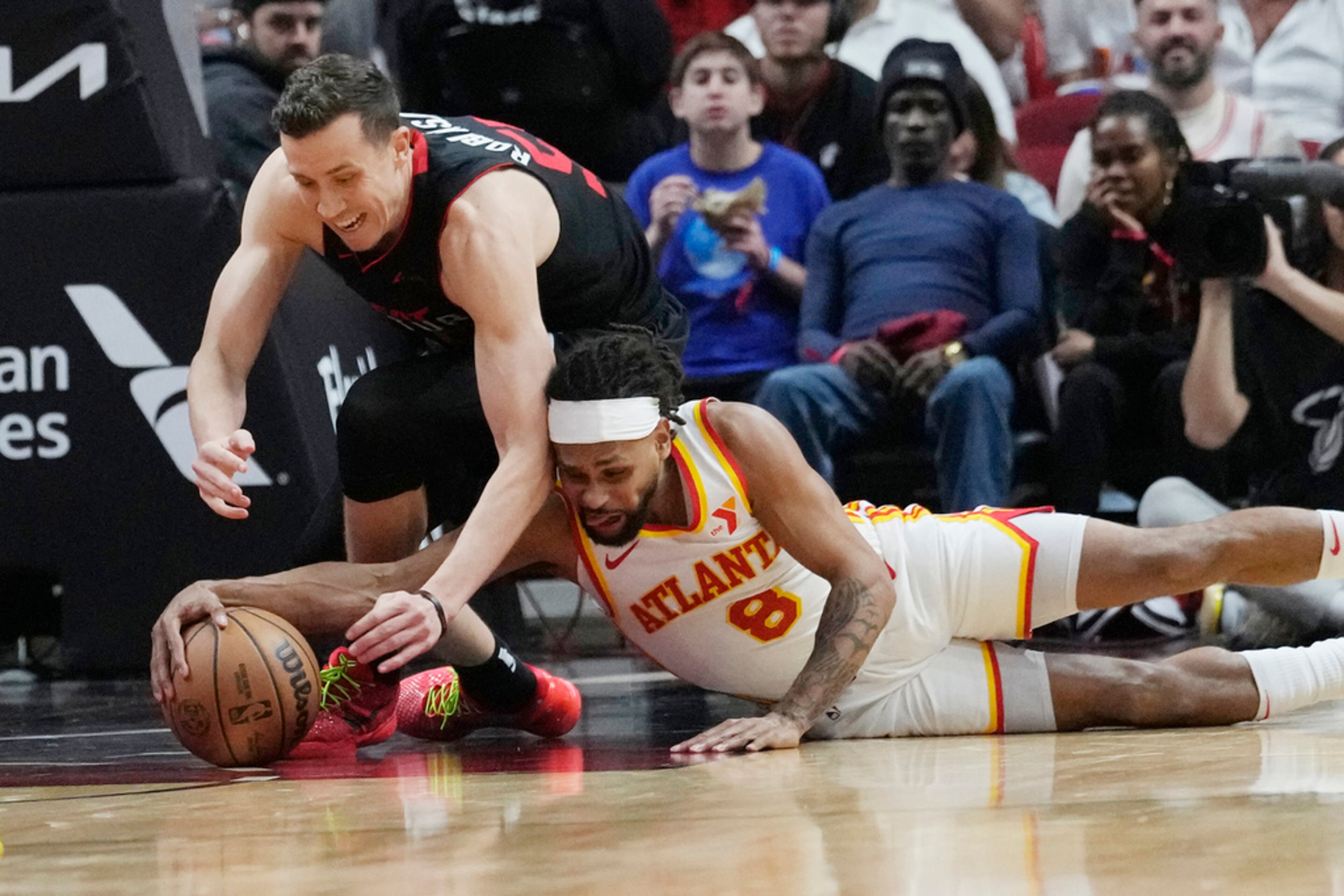 Atlanta Hawks guard Patty Mills (8) and Miami Heat forward Duncan Robinson (55) go after the basketball during the second half of an NBA basketball game, Friday, Jan. 19, 2024, in Miami. (AP Photo/Marta Lavandier)