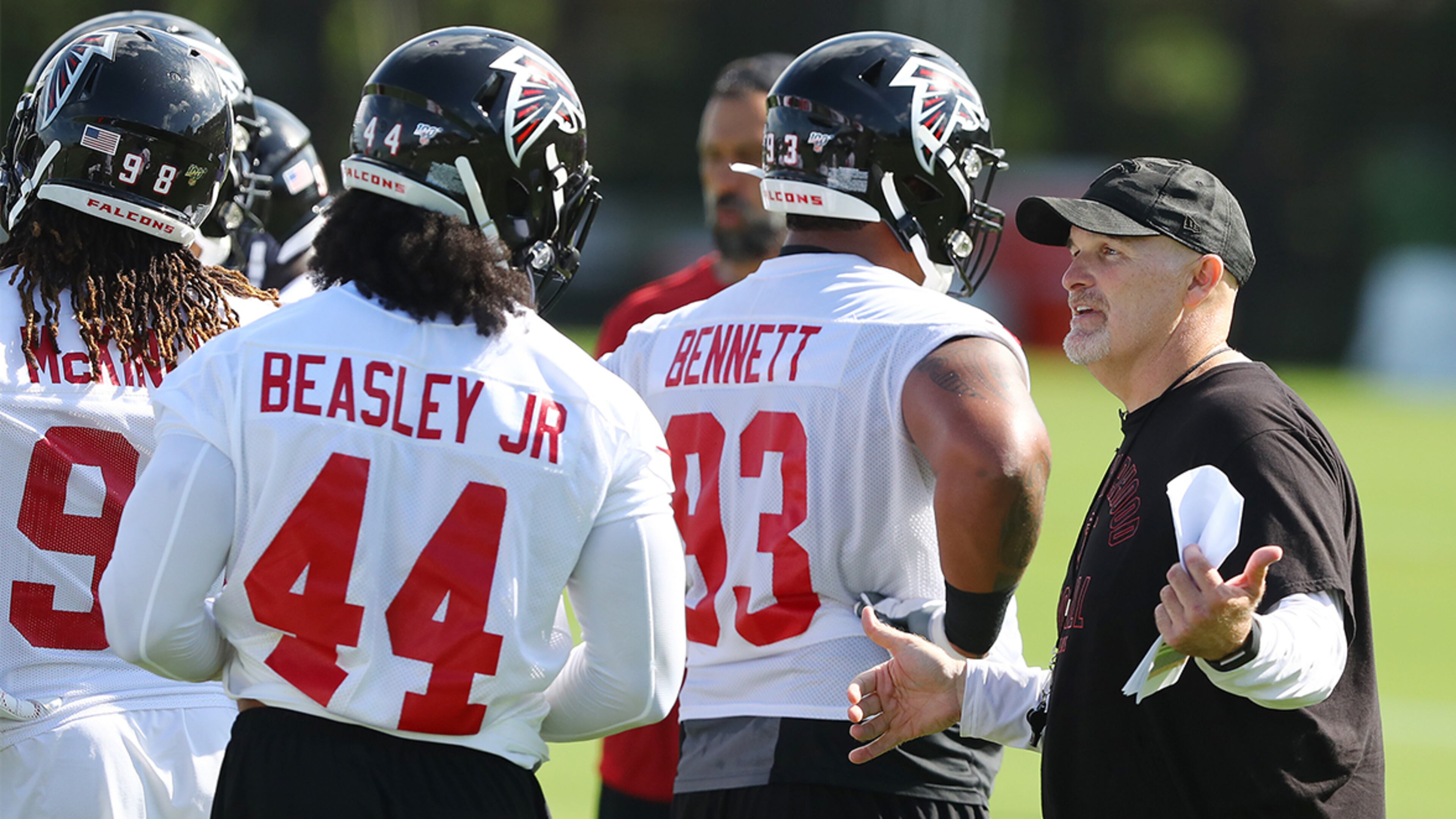 Falcons head coach Dan Quinn works with Vic Beasley after a play during the first practice of training camp Monday, July 22, 2019, in Flowery Branch.