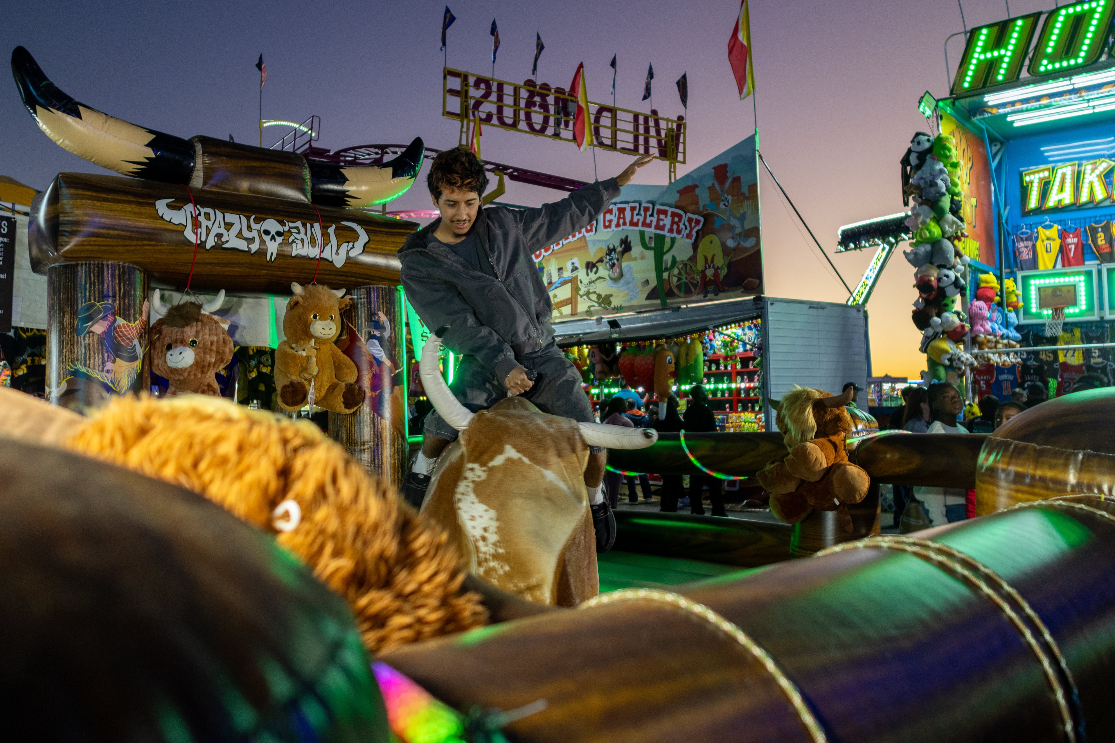 Bruce Fonguin focuses as he rides the mechanical bull while the sun sets at the 37th annual Georgia National Fair on Saturday, October 17, 2026. Fonguin, from Warner Robins, Georgia, has been to the fair about six times already in his life. (Wesley Webb/UGA Photojournalism Workshop)