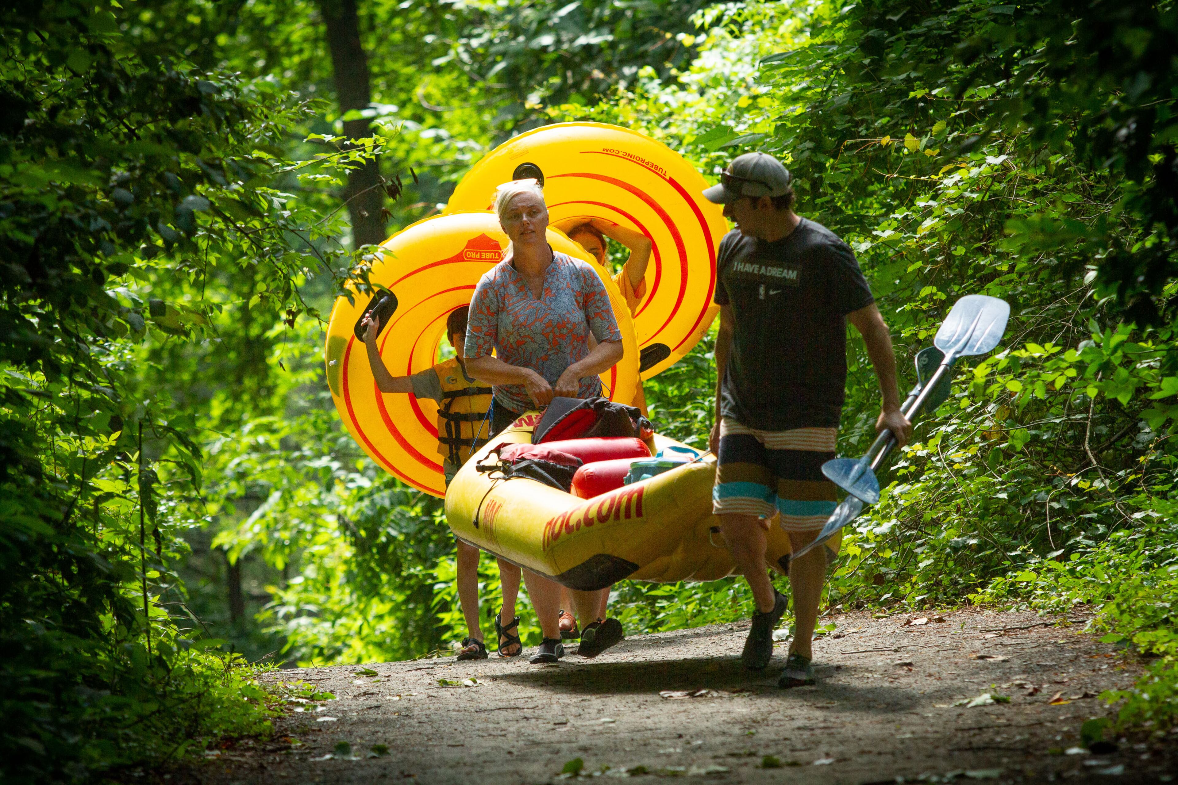 Jessica Levin (left) and her husband, Jeremy, carry their boat to the Chattahoochee River at Powers Island Park in Sandy Springs on Sunday, June 28, 2020. STEVE SCHAEFER FOR THE ATLANTA JOURNAL-CONSTITUTION