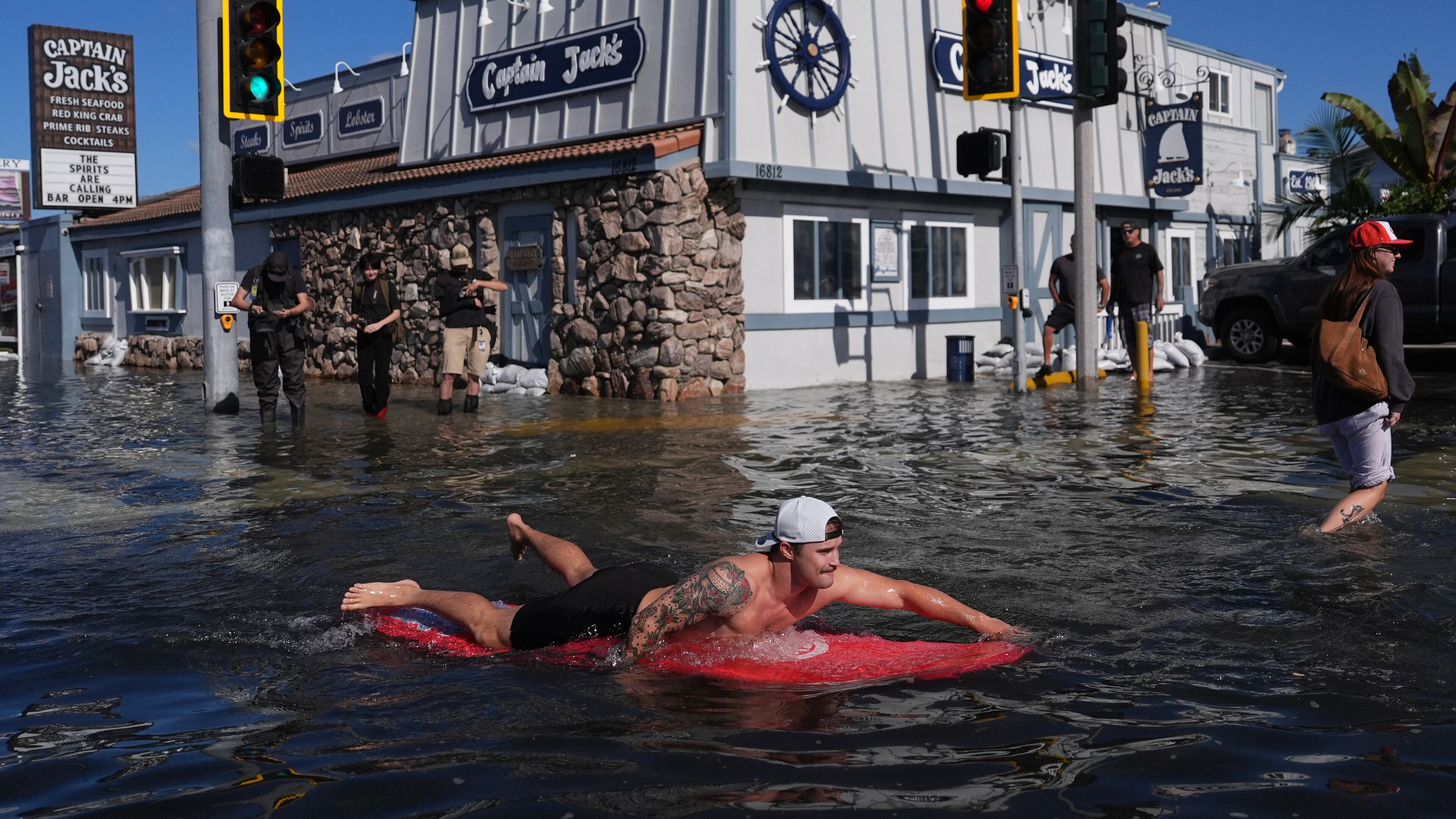 A man surfs through floodwaters in Huntington Beach, Calif., Wednesday, Oct. 28, 2026. (AP Photo/Jae C. Hong)