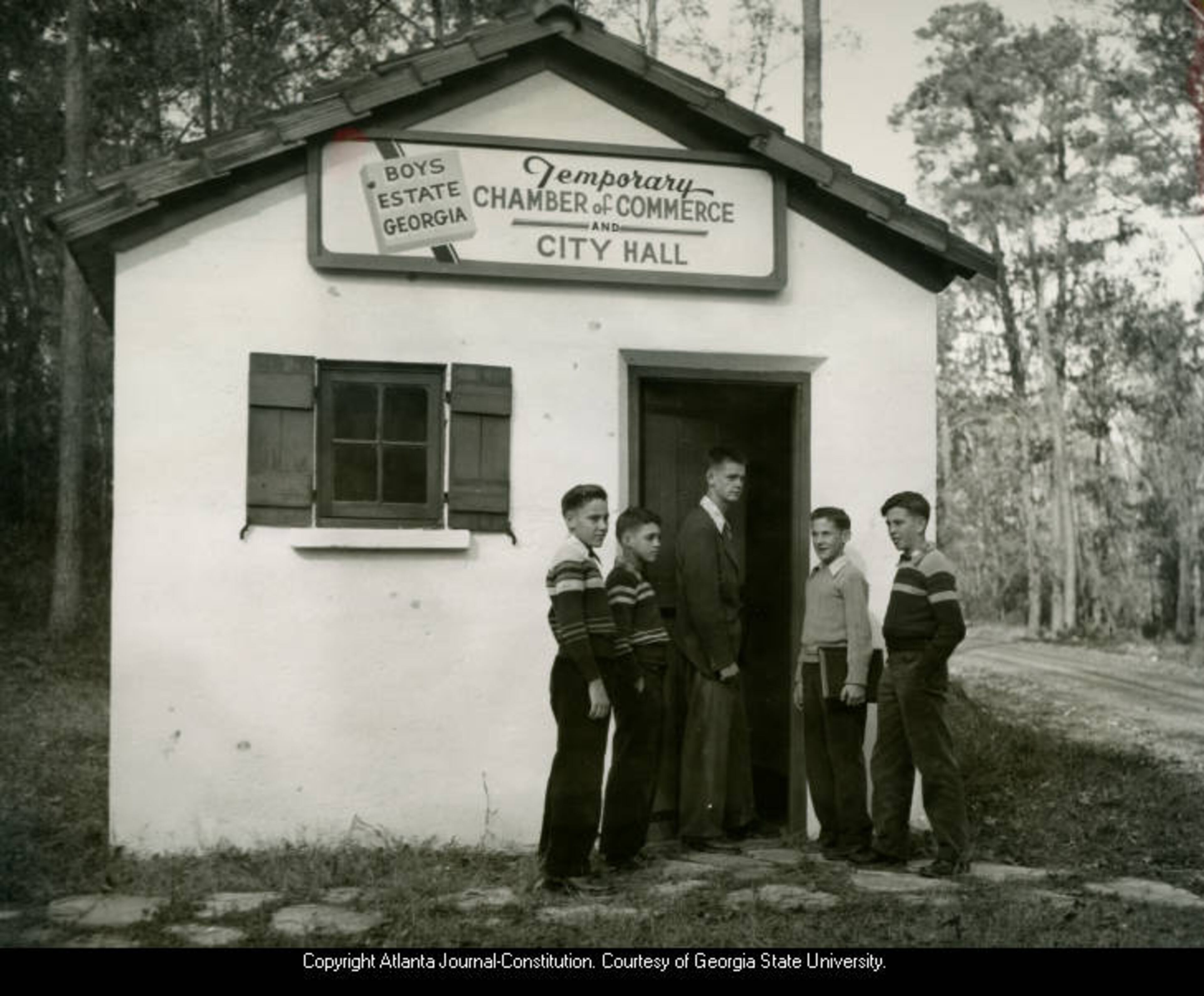 1945 -- Original caption: "The city council enters the temporary city hall and chamber of commerce building for a session. The politicos are (left to right) Irwin Parker of Albany, Norman Taylor of Waycross, Mayor Gene Poss of Atlanta, Melvin Lavier of Albany and Sonny Taylor of Waycross." AJC PHOTO ARCHIVES