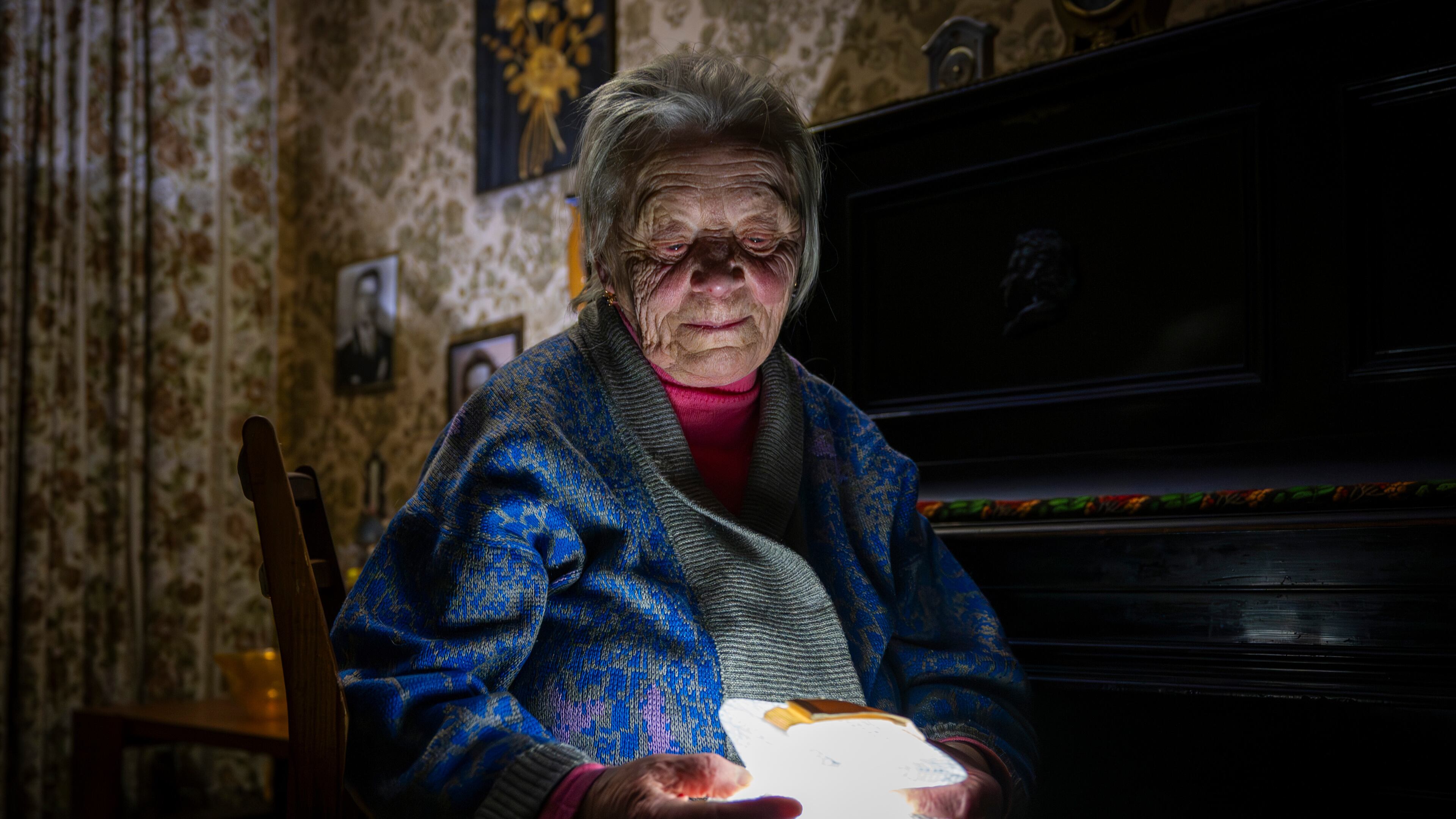 Raisa Derhachova holds a homemade flashlight during a power outage caused by regular Russian air strikes on the country's energy facilities in Kyiv, Ukraine, Tuesday, Jan. 13, 2026. (AP Photo/Dan Bashakov)